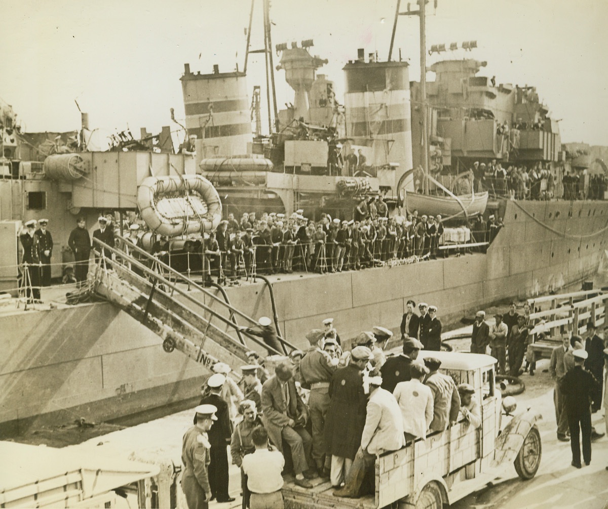 Wounded Axis Prisoners Landed at Malta, 2/2/1943. Malta—British destroyers lying alongside each other discharge prisoners of war and have come down the gangway and are loaded into lorry in foreground. British sailors line the ships’ rails watching the prisoners, who were picked up from the water after their merchant ships, running from Italy, were attacked. Credit: ACME.;
