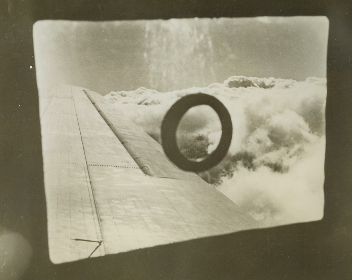 IN EVEN OF ATTACK-REMOVE PLUG, 3/9/1943. CHINA—The strange-looking plug in the window of a transport plane speeding over the Himalayas stops a hole that’s a perfect fit for a tommy gun. In  the event of air attack on the aerial supply route between India and China, passengers and crew remove the plug and fill up the hole with a machine gun. This U.S. transport plane is flying high to avoid bad weather below.  Credit: ACME.;