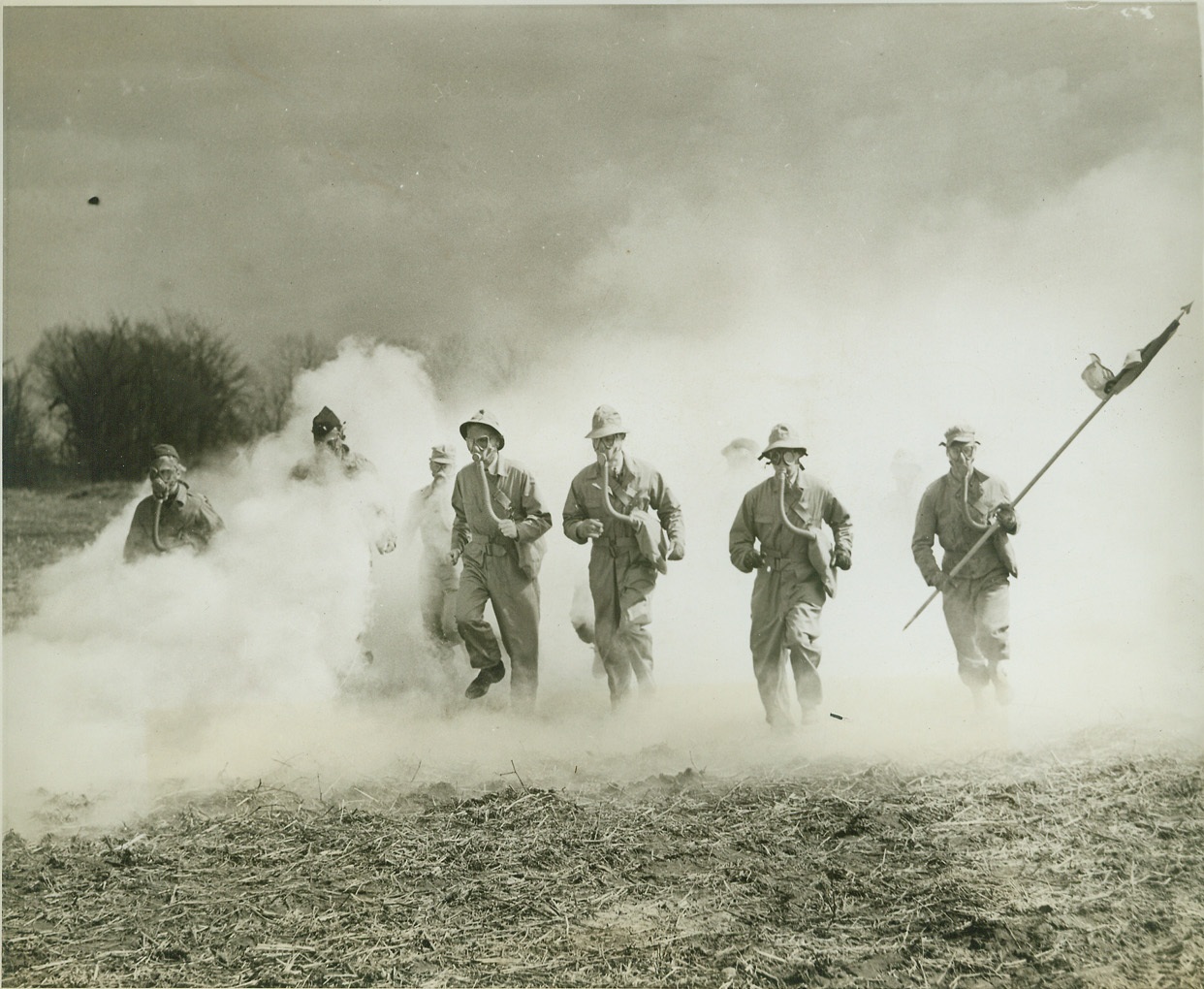 Army Camp “Guests” Learn Chemical Warfare, 3/23/1943. Camp Atterbury, Ind.—Some of the 250 members of the CIO-UAW who are guests at Camp Atterbury, Ind. Where they are spending three days learning how a soldier works and lives, don gas masks and are put through a chemical warfare drill. Credit: ACME.;