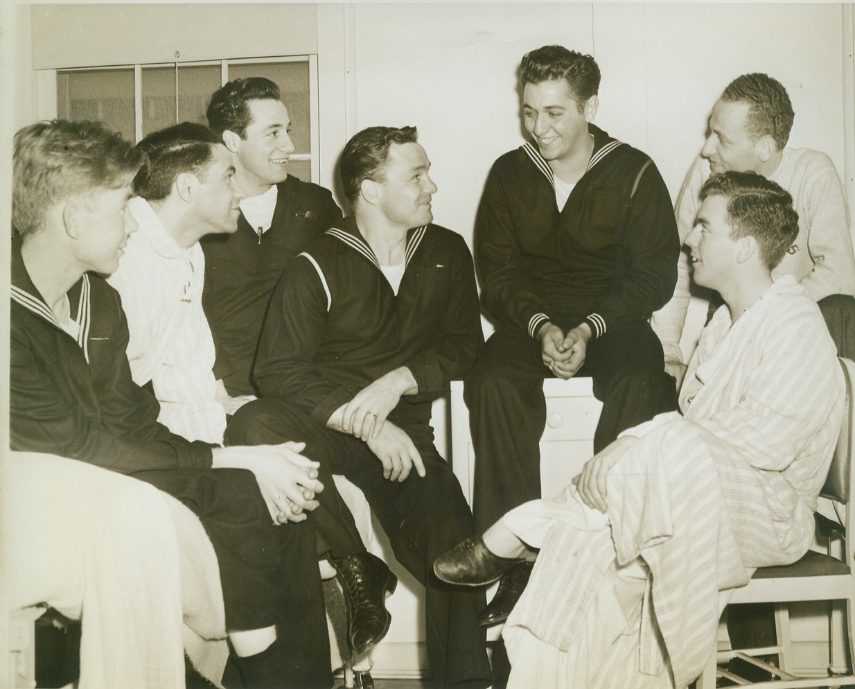 He Lives to Tell the Tale, 3/12/1943. Bethesda, MD.—Basil Izzi, of South Barry, Mass., who was one of the three survivors of five who drifted on a raft on the South Atlantic for 83 days, relates his experiences to fellow patients at the Naval Hospital here. Left to right: Dominic Hutchison, Mims, Fla.; Emil Heifitz, Cleveland, Ohio; Joseph Castelluci, Somerville, Mass.; Joseph Marinko, St. Louis, MO.; Izzi; Al Silver, Baltimore; and Ed Parker, Richmond, VA. Credit: ACME.;
