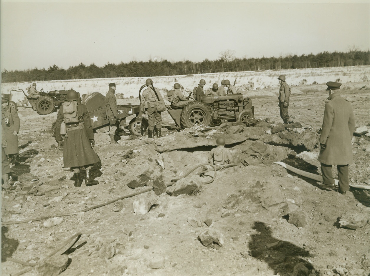 Getting to Work, 3/3/1943. Westover Field, Mass.—Their equipment unloaded from the planes that brought them to the site of a bomb explosion, airborne engineers, training at Westover Field, begin to repair the damaged earth runway. Credit: ACME.;