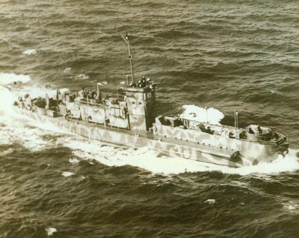 NEW TYPE INVASION BARGE, 5/22/1943. Ready to carry troops where they’re needed, this new-type invasion barge, the Navy’s L.C.I., cuts through the water off the Atlantic coast. The camouflaged vessel operates under the Navy Amphibious Force. Credit (Official U.S. Coast Guard Photo – ACME);