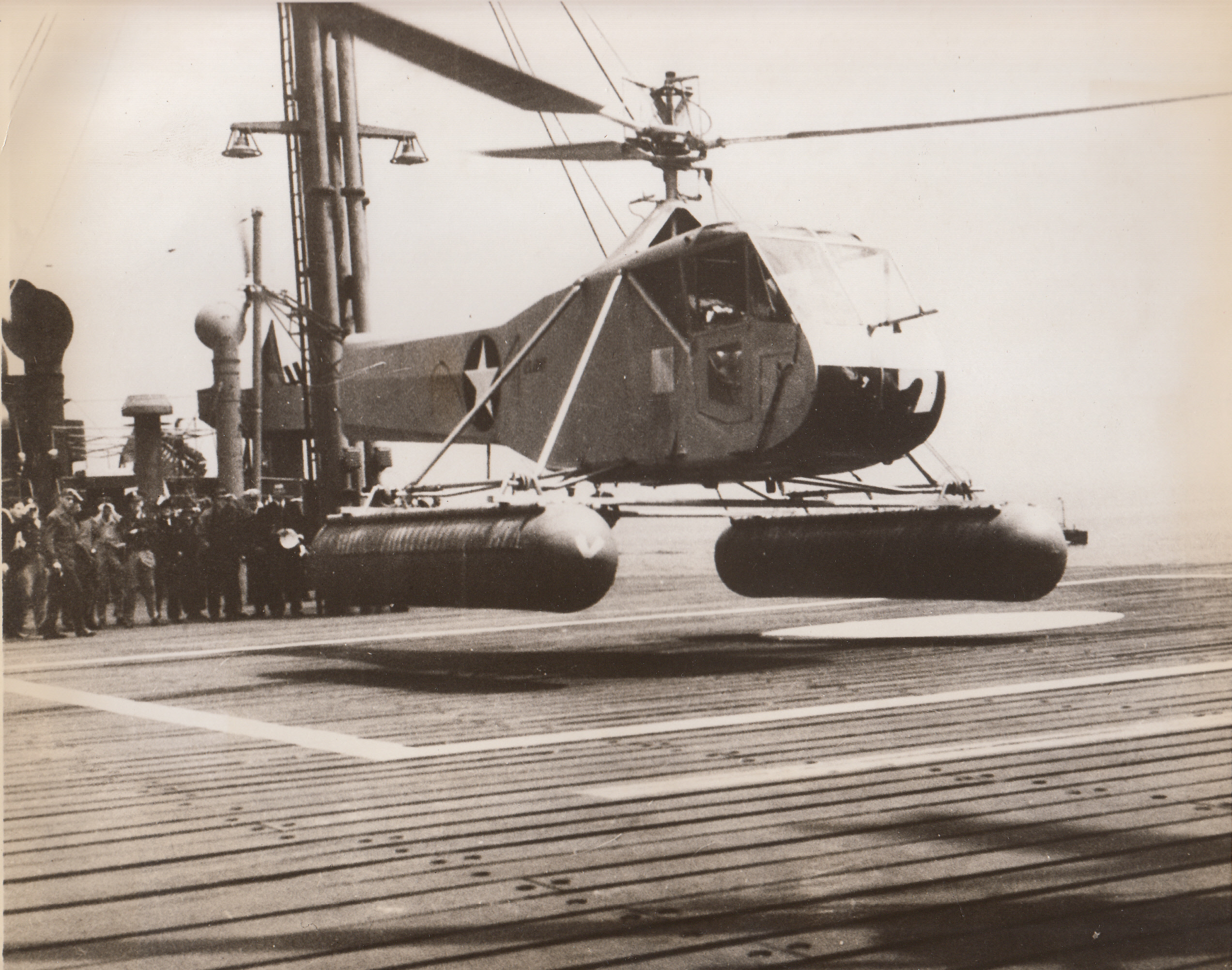 Helicopter Takes to the Ocean, 5/25/1943. A helicopter hovers over a small square marked off on the deck of a tanker, performing the tiny-space landing to prove its value as a sub fighter. In a recent demonstration on Long Island Sound, the wingless aircraft made 24 landings and take-offs from the small deck of a moving tanker. The craft, known as the Army Air Forces R-4 Helicopter, is an AAF development. A plan is in progress to install a small deck on Liberty ships to permit helicopters to be used at sea in anti-submarine duty.;