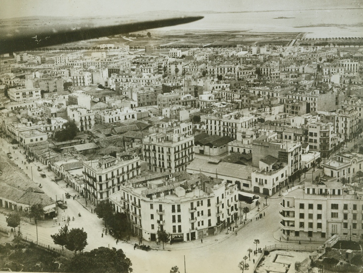 The City Still Stands, 5/22/1943. Tunis—Although Allied bombers pounded heavily at dock installations and military objectives in Tunis while the city was still held by the Axis, the center of the town was left almost intact. Untouched by bombs, this is how Tunis looked from the air soon after American, British, and French troops moved in. Only the trench at bottom right remains as a reminder of warfare that once raged in Tunis.Credit: ACME.;