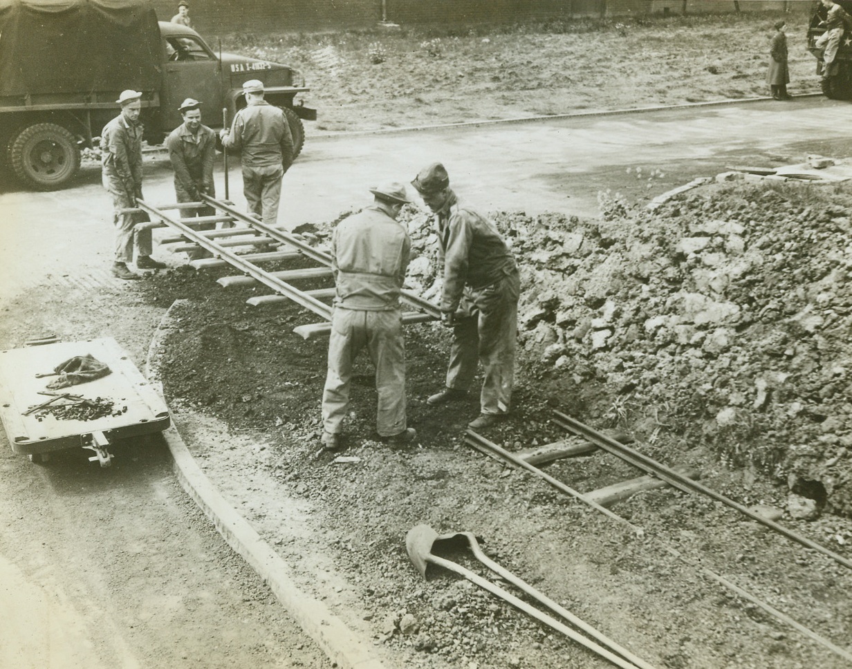 The Last Track, 5/22/1943. Somewhere in England -- American Army engineers lay the last bit of track for the 17-mile, narrow gauge railroad, built and operated by U.S. forces at an Army Supply Depot in England. The road was build to haul supplies between Army warehouses and unloading and shipping points in Britain. Credit: ACME;