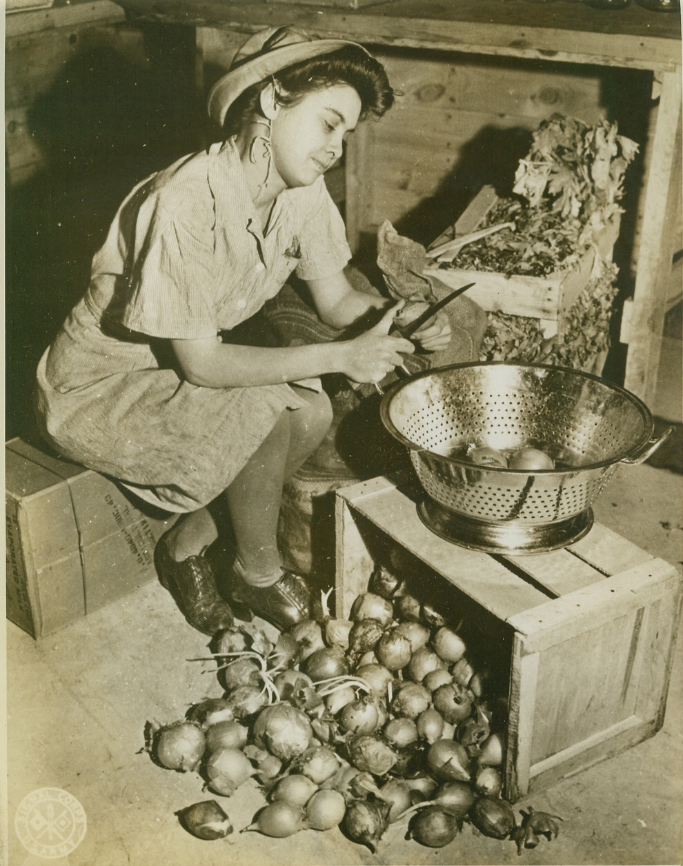 DON’T CRY, LITTLE GIRL, 1/3/1943. FORT DEVENS, MASS. – If there are tears in WAAC Ruth Ballard’s eyes, blame it on the onions. If she joined the Army to escape the kitchen, tho’, she’s a mighty disappointed young lady, because she drew a KP assignment during her first day on duty at Fort Devens. Credit: Signal Corps photo from ACME;
