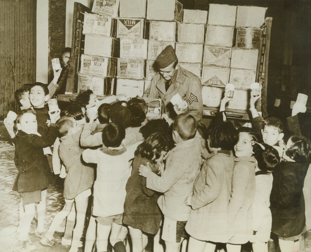 Milk for Children of Oran, 1/14/1943. Oran, Algeria—Eager hands reach for cans of condensed milk, as Sgt. Paul Myers, U.S.A., of Missouri, distributes half the milk ration of U.S. troops in Oran to French children living in the North African town, recently occupied by Anglo-American forces. (Passed by censors) Credit: ACME.;