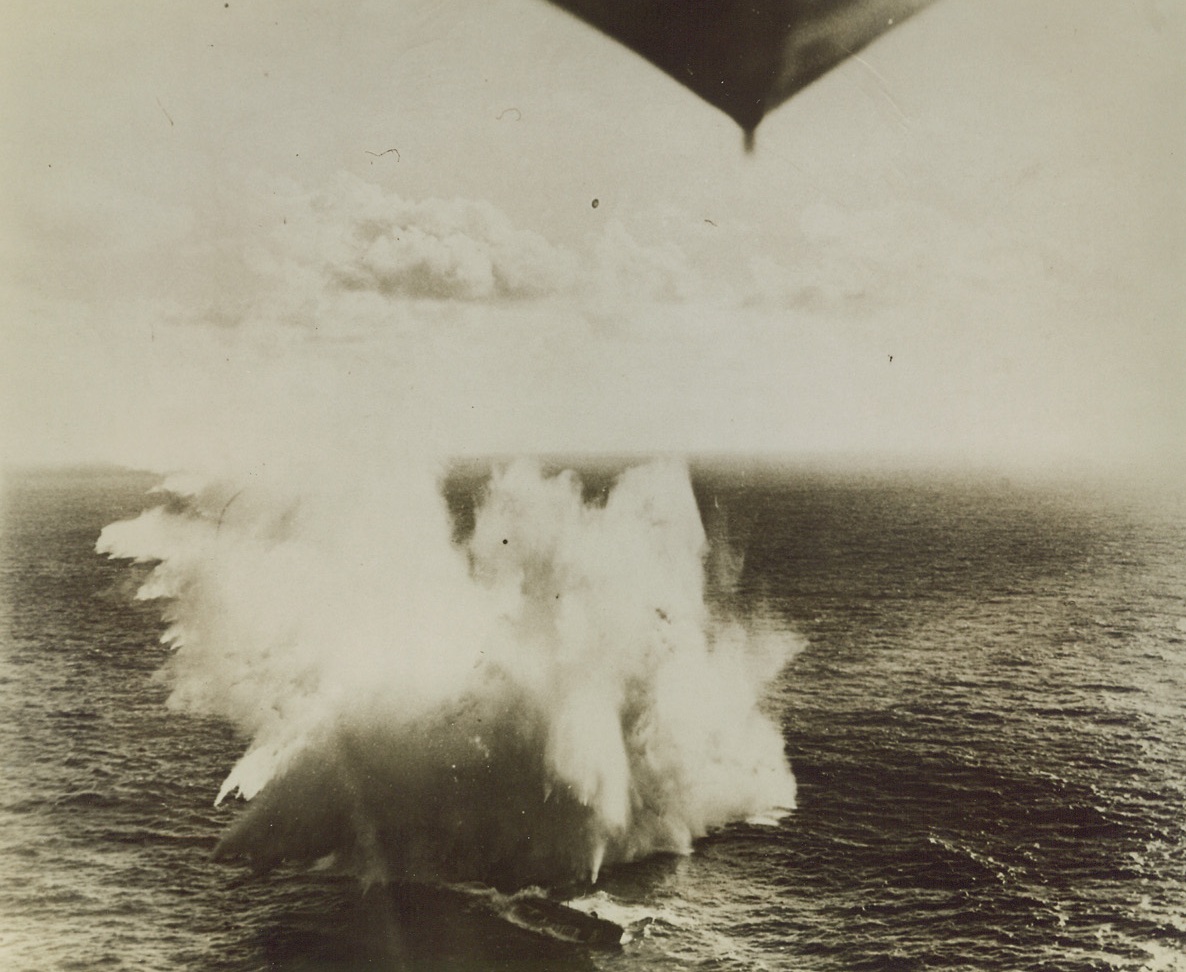 Blasting Nazi U-Boat, 9/21/1943. This photo, released by the U.S. Navy Department today, shows exploding depth bombs from a U.S. Navy Martin Mariner (PBM) patrol bomber straddling a German submarine “somewhere in the South Atlantic.” The disabled U-boat was finished off later by U.S. destroyers. Prow and conning tower of the sub can be seen just below the center of smoke column. Part of the plane from which the photo was taken can be seen in the picture, (top, center). the attack took place in 1943. Credit Line (U.S. Navy Photo from Acme);