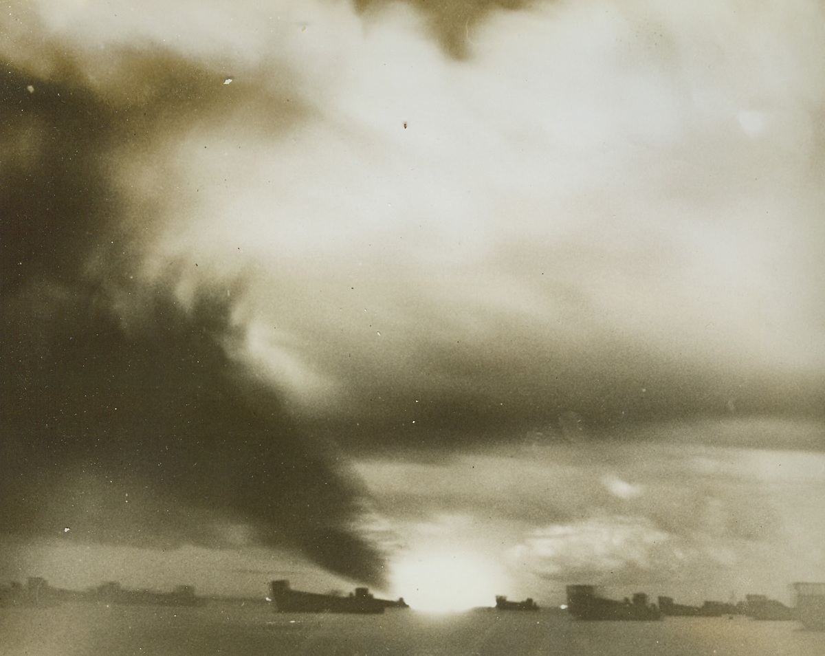 U.S. Transport Burns, 9/30/1943. GuadalcanalBurning fiercely after oil stores had been set aflame by an exploding torpedo, the U.S. Navy Transport John Penn casts a sunset-set like glow in the evening sky off Lunga Beach, Guadalcanal. The ship was hit by a Jap sneak attack by torpedo plane Aug 13th last, which came in low while a “Decoy” flight of Jap Bombers carried out a high-altitude attack. One of the decoys was shot down by a U.S. night fighter and the nip torpedo bomber was believed to have been shot down in flames by anti-aircraft fire. All troops and cargo had been removed before the attack on the John Penn, which sank within an hour.Credit: U.S. Marine Corps Photo from Acme.;