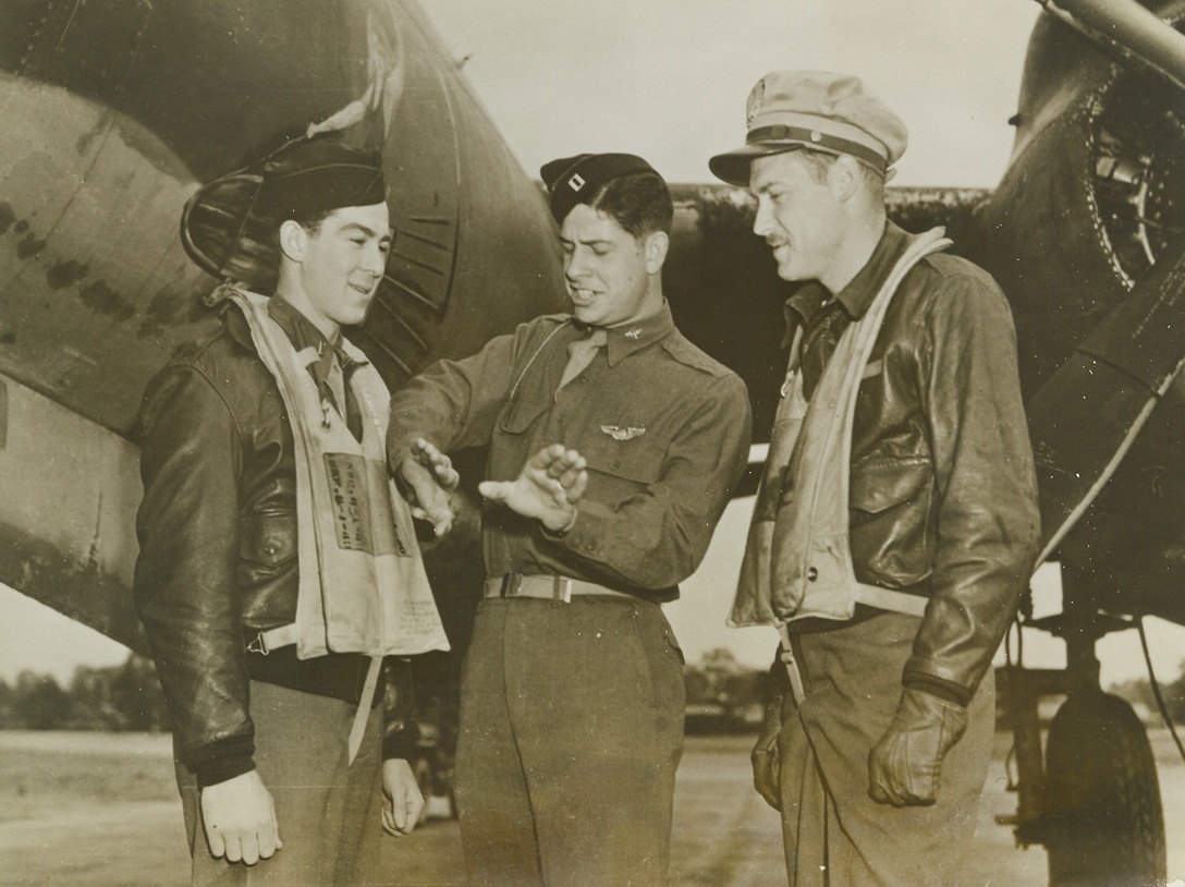 Planning Their Route, 9/19/1943. Somewhere in England – Chatting before their plane at a U.S. Marauder base somewhere in England, these pilots discuss their plans for a raid over Axis Europe. Left to right: 1st Lt. Robert W. Wilcox of Rice Lake, Wisconsin; Capt. Robert C. Fry of Abilene, Texas; and 1st Lt. Harry W. Uffelman. Credit: ACME;