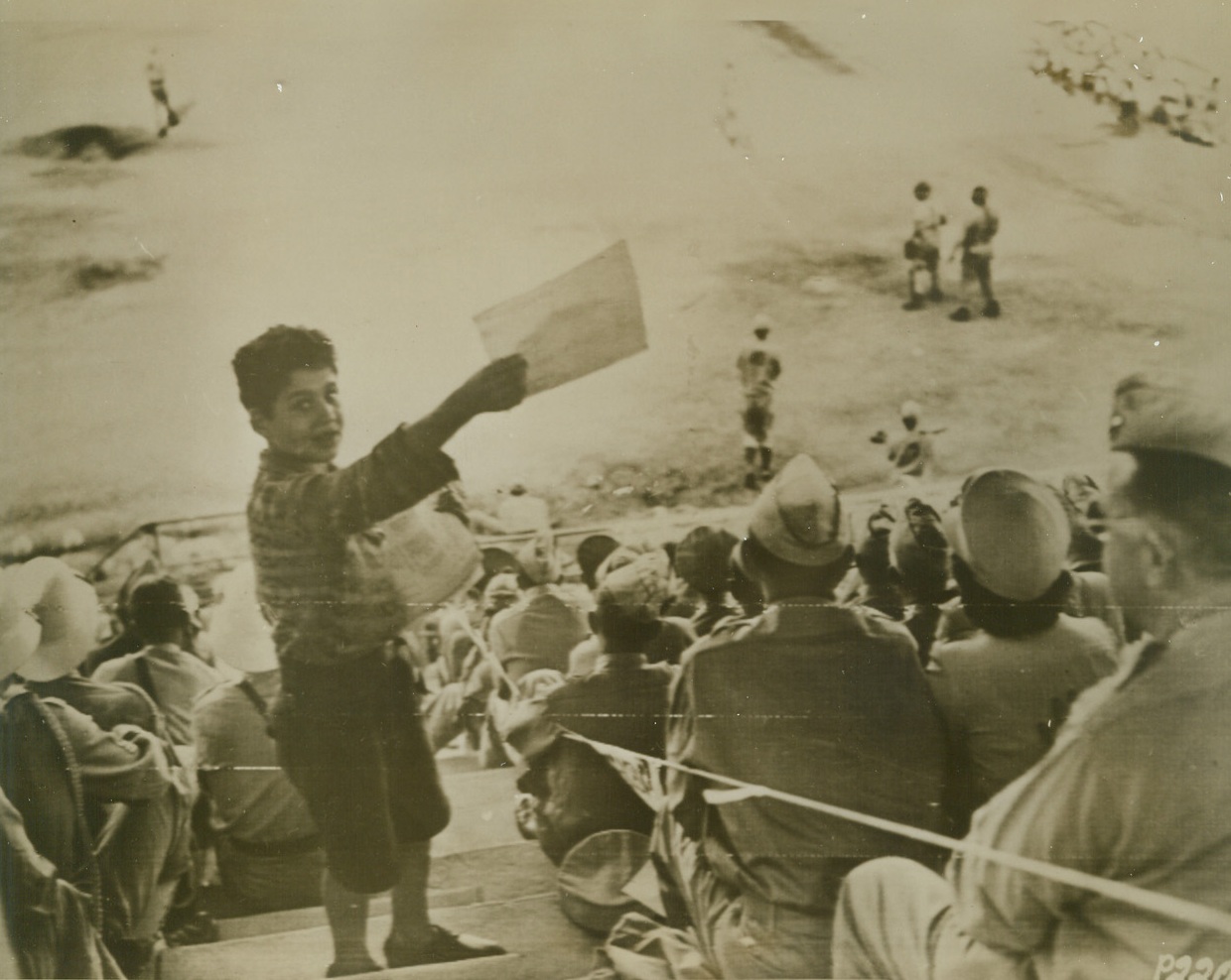 North African “World Series”, 10/4/1943. North Africa – A young Arab lad does a big business selling programs in a packed stadium in North Africa, where the Casablanca “Yankees” took the opening baseball game of the North African “World Series”, from the Algiers M.P.S by a score of 9 to 0.  This picture was flashed to the U.S. by radio telephoto today. Credit line (ACME photo for the war picture pool by Bert Brandt via U.S. Signal Corps);