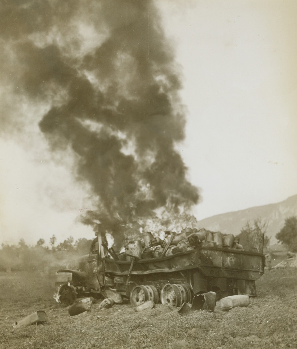 ALLIED GAS TRUCK HIT BY NAZIS,  11/23/1943. WITH THE 5TH ARMY IN ITALY—An Allied truck loaded with cans of gasoline burns fiercely after being strafed by German planes “somewhere on the Italian Front.” Enemy air attacks in this sector were extremely heavy when this photo was taken.  Credit Line (ACME Photo by Bert Brandt for the War Picture Pool);
