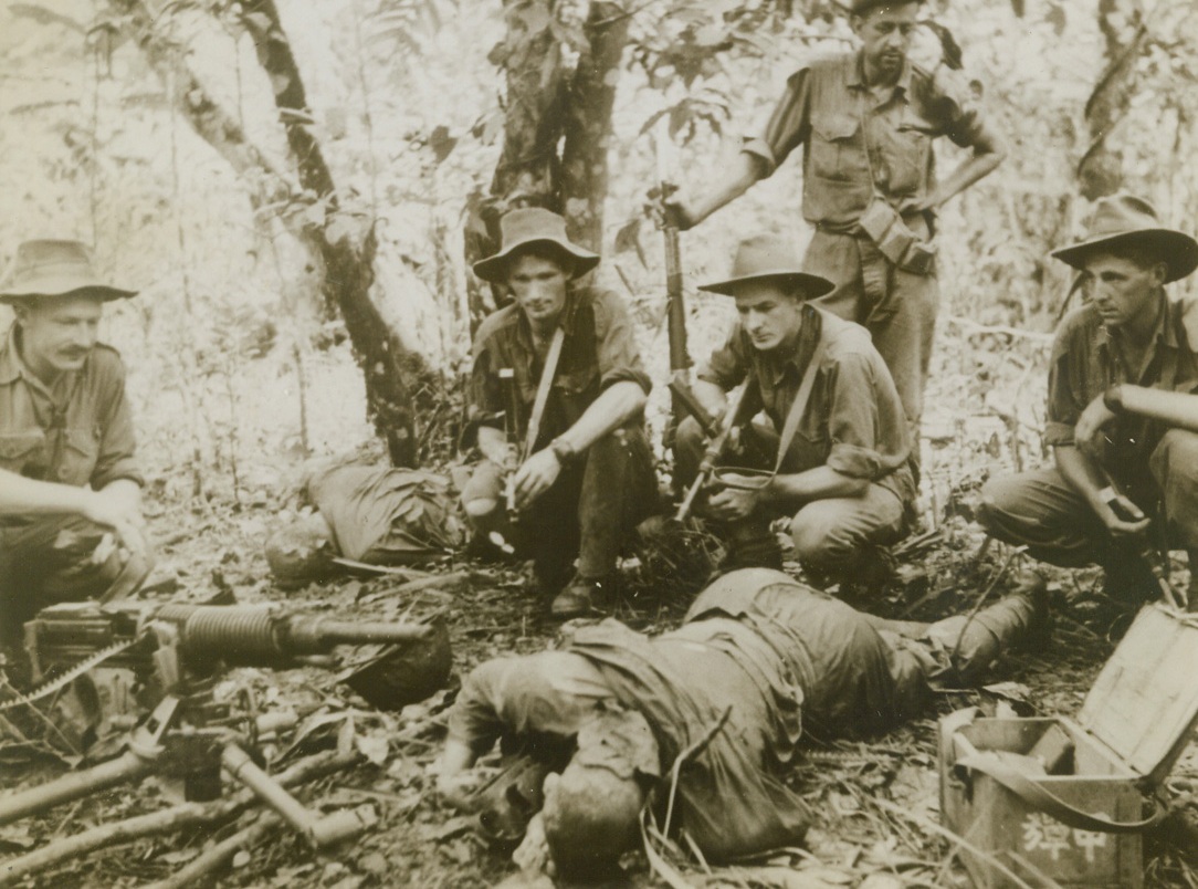 Jap Gun Nest Blitzed, 11/22/1943. New Guinea – An Australian patrol wiped out this Jap forward machine gun post during the advance along the Upper Ramu Valley.  Here members of the patrol examine the erstwhile enemy gun nest.  Note Jap letters on case at right. Credit line (ACME);