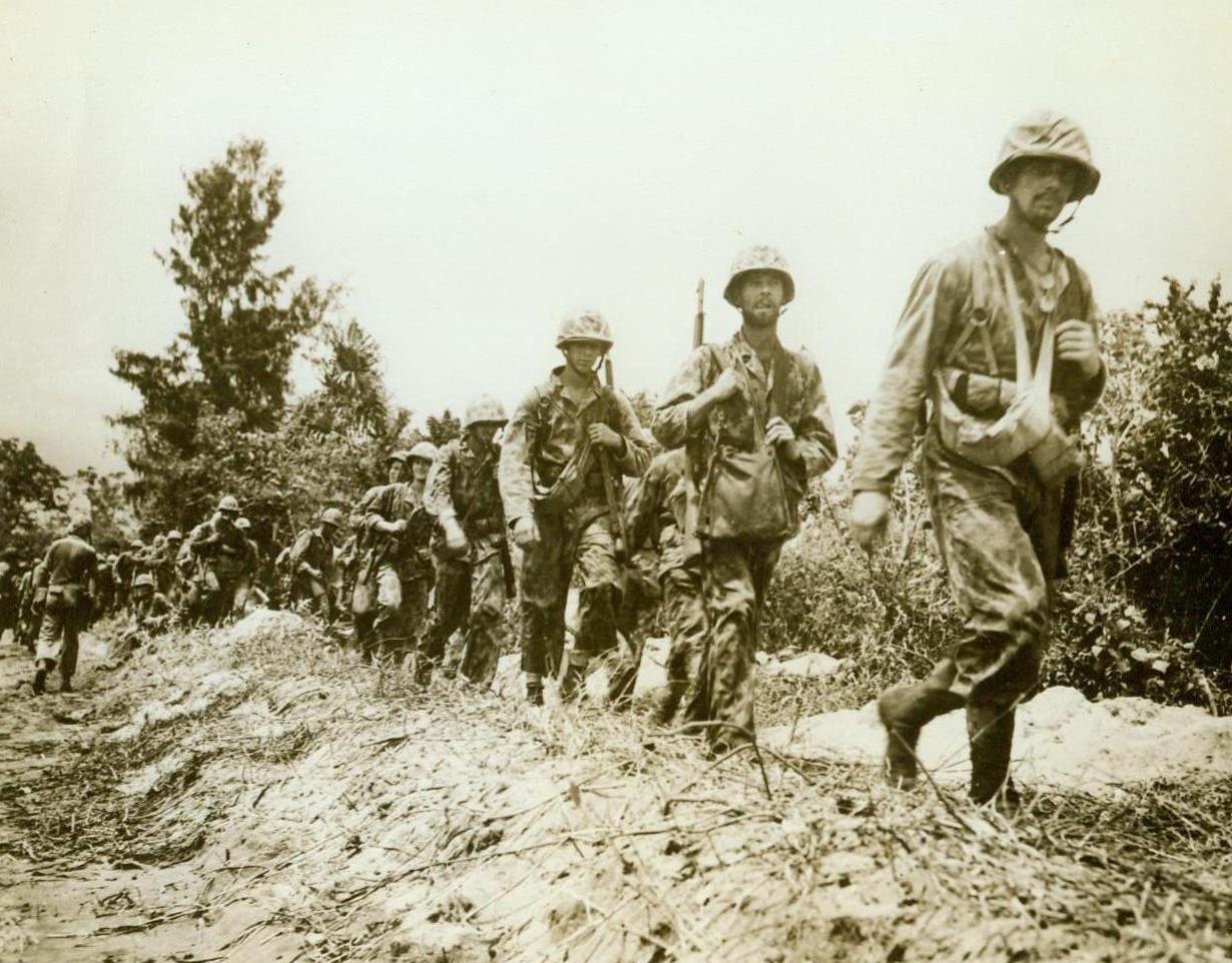 The Morning After, 11/26/1943. Bougainville Island -- Wet and weary, after an all-night vigil in Bougainville foxholes, Marine Raiders tramp along the lane that runs from Cape Torokina to Piva Village as they return to their base. Members of the Piva Patrol, these fighting men were ordered to use only cold steel (their knives and bayonets) when the Japs attacked, in force, on the Piva road block. 11/26/43 (ACME);