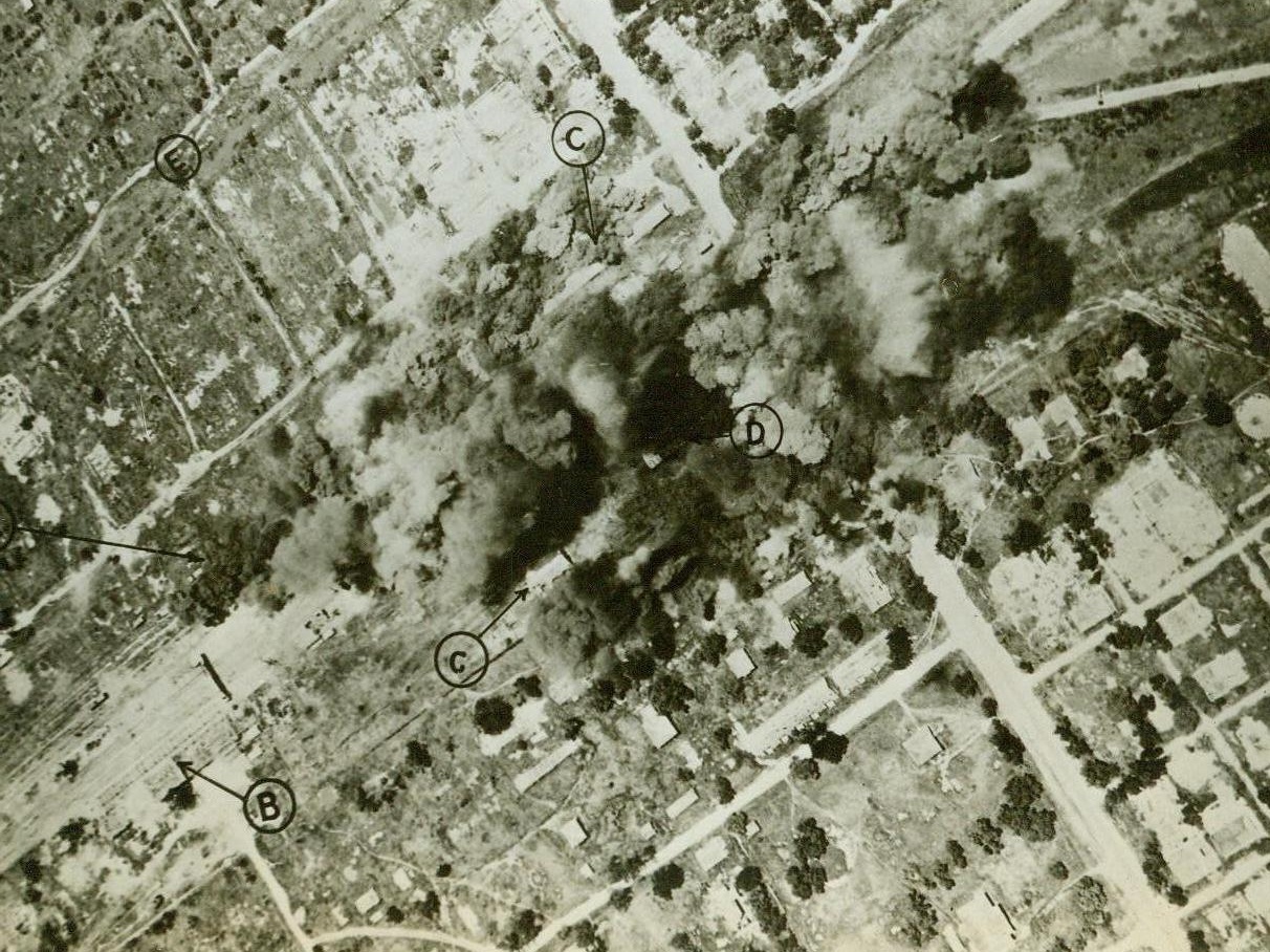 Bombs for Burma, 11/1/1943. This photo, just released in the United States shows bombs from American aircraft dropping on the important railroad junction at Thazi, Burma, during a recent raid. The letter “A” identifies tracks, while “B” shows warehouses, “E”, blasted warehouses, and “C”, trackage and sheds. 11/1/43 (U.S. Army Photo From ACME);