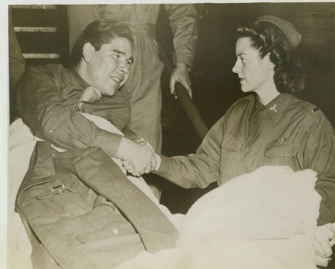 First American Wounded Repatriated From Germany, 11/3/1943. Washington, D.C.—Cpl. Rodney M. Graham, of Atoka, Okla., gives his thanks and bids farewell to 2nd Lt. L.E. Mathis, of Cape May, N.J., who accompanied the men on the trip as a flying nurse, upon arrival at Washington by plane. Graham was among the fourteen wounded American soldiers repatriated from Germany, the first under an agreement for the exchange of sick and wounded prisoners. The fighting men were then sent to Walter Reed Hospital. Credit: U.S. Army official photo from ACME.;