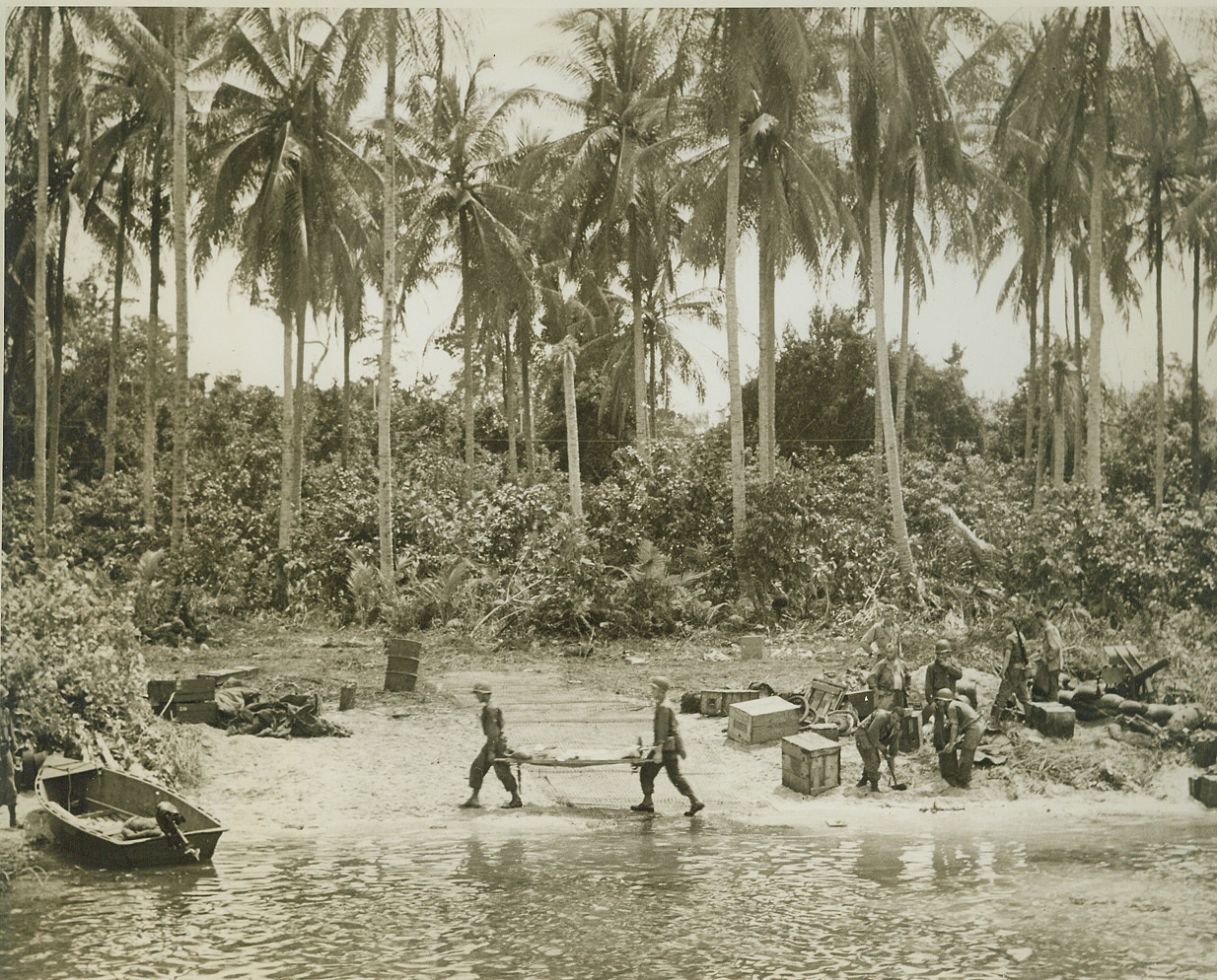 Wounded in Battle, 12/29/1943. Arawe, New Britain – Wounded in the fighting at Arawe, a stretcher-borne Yank is carried through the shallow water on the island’s shore. A group of Yanks work on the littered beach at right. Latest reports from New Britain indicate that our troops have pushed to within striking distance of the Cape Gloucester airstrips, 50 miles southeast of Arawe Credit: -WP-(Photo by Thomas L. Shafer, ACME Correspondent for War Pool);