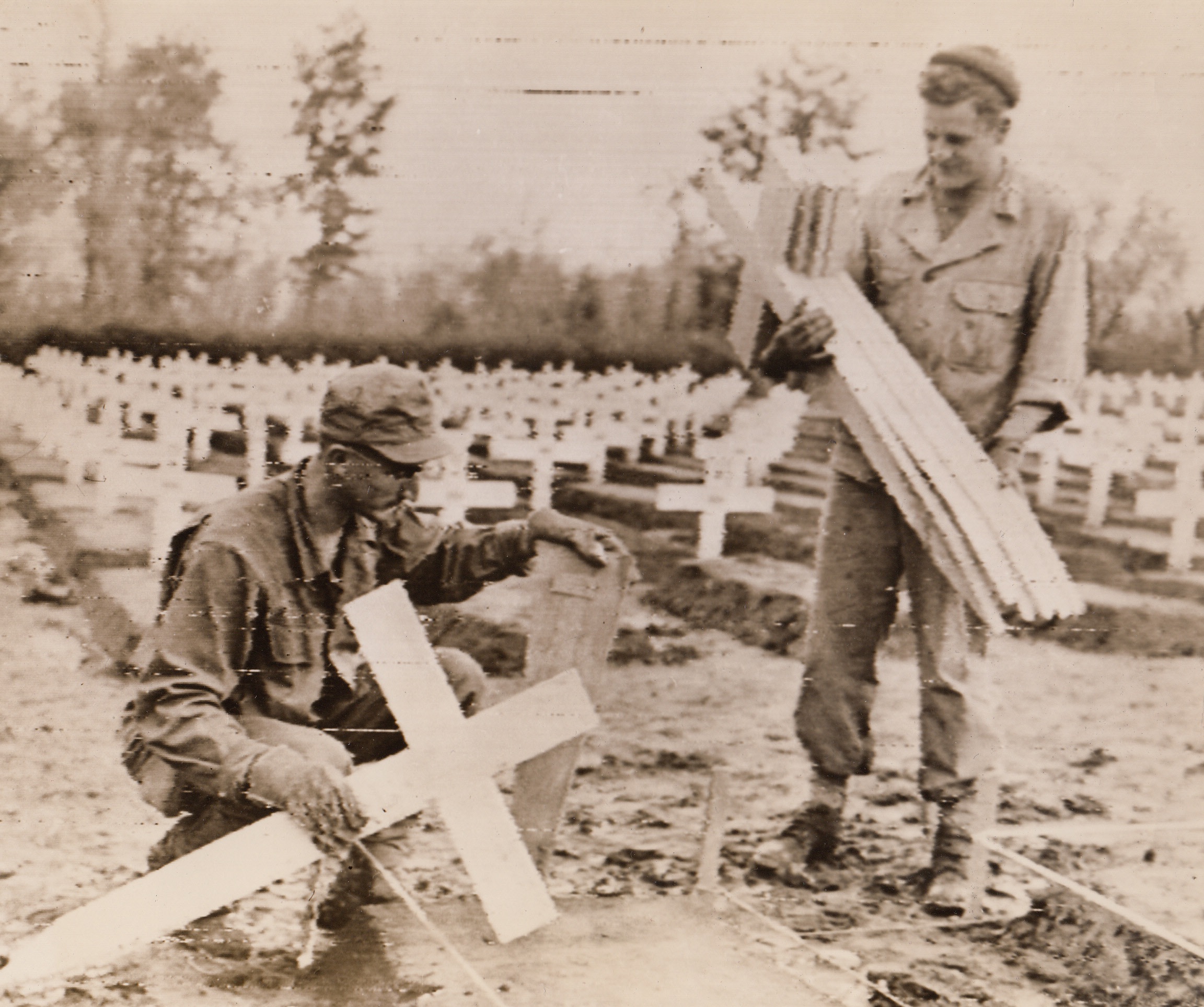 White Crosses Mark Our Graves In Italy, 12/11/1943. Italy –Row upon row of neat white crosses mark the graves of U.S. fighting men who are buried in Italy. Here, two American soldiers replace the temporary markers with the crosses and identification tags. 12/11/43 Credit (U.S. Signal Corps Raidiotelephoto From ACME);