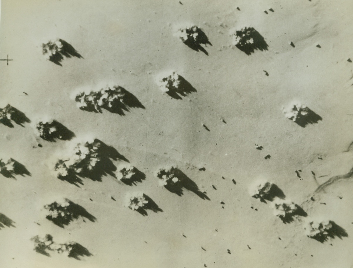Blasting Rommel’s Motor Transport, 10/2/1942. Egypt—More than a score of bombs burst on a concentration of Nazi Field Marshal Erwin Rommel’s motor transport units on the Western Desert during an attack by light bombers of the Allied air force. Passed by British censor. Credit: ACME.;