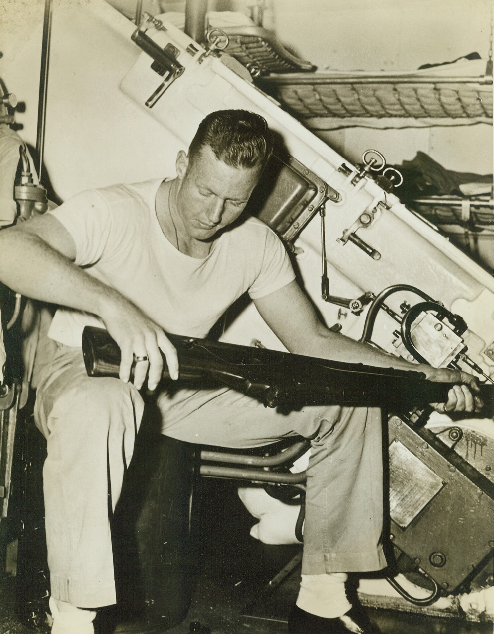 A Marine and His Pal at Sea with Fleet, 4/18/1942. At Sea – If every husband gave his wife the loving care that a U.S. Marine gives to his rifle—there would be nary a divorce. This Leatherneck is grooming his weapon while off duty aboard one of the heavy-hitting units of the U.S. Atlantic Fleet on the ocean highways of Europe. Approved by U.S. Navy. Credit: ACME;