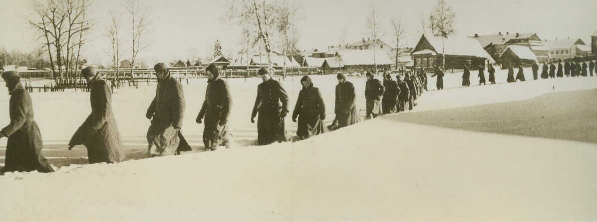 Long Trail of Defeat, 5/18/1942. RUSSIA - Just received from the Northwestern front is this picture showing a fresh batch of German war prisoners being marched off to the rear of the Soviet lines through deep snow.;