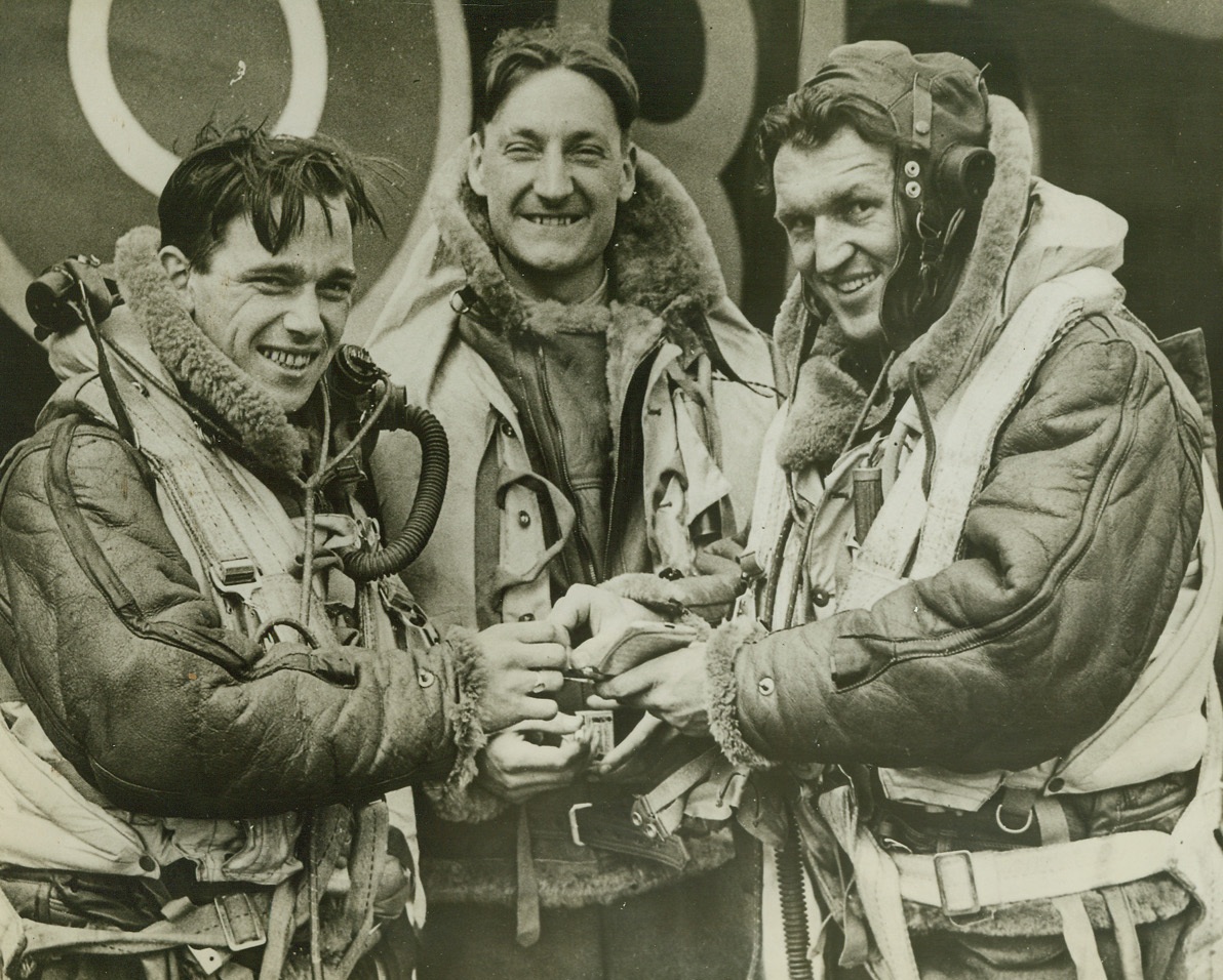 Back Home Tired But Happy After 1,000-Plane Raid, 6/9/1942. An English Bomber Station - Three of the Gunners of a huge Stirling Bomber, that took part in blasting Cologne, recently, are shown back home at their station, tired but happy after the raid. They are shown about to enjoy a well-earned cigarette. One thousand planes took part in the attack on the German city. (Passed by Censors). Credit: ACME;