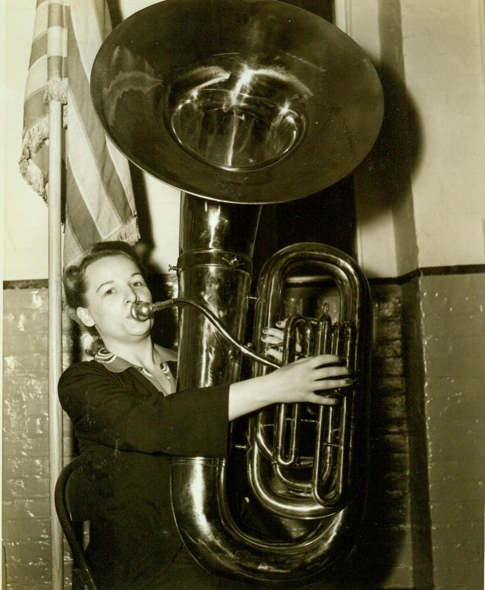 SWORN IN AS W.A.A.C. BAND MEMBER, 7/30/1942. NEW YORK, NY – Miss Janet Rose Montgomery, 29, blows a tune on her horn after being sworn in as one of the first members of the W.A.A.C. Military Band, at the Headquarters of the Southern New York Recruiting and Induction District, 39 Whitehall Street. Miss Montgomery who is from Detroit, Mich., has had considerable experience with bands in the Middle West. She will report to Ft. Des Moines, Iowa, August 3rd. Credit: ACME;