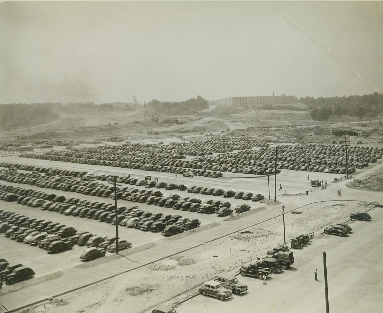 War Department Workers Jam Parking Space, 7/30/1942. WASHINGTON, D.C. – Although the new War Department pentagon building is not fully occupied, thousands of automobiles jam the parking space adjacent to the new building. The field is especially laid out to accommodate workers in the new building. Credit: (ACME);