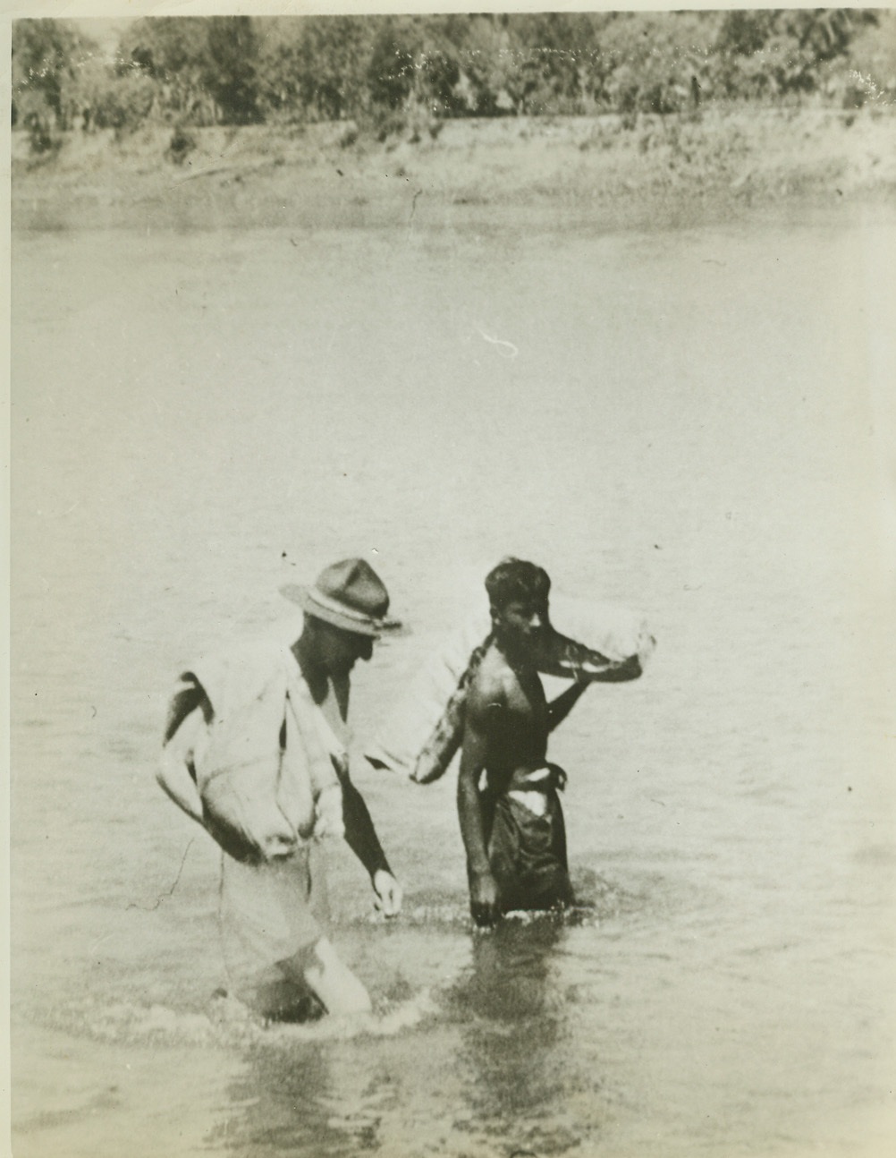 One of the most unusual photos, 7/30/1942. One of the most unusual photos in military history, it shows Lt. Gen. Joseph W. Stilwell, clad in underware, wearing a campaign hat, and with cigarette holder cocked at a jaunty angle, wading out to a raft with a sack of bully-beef over his shoulder. A RAF Blenheim bomber has just dropped food to the column, and the General is doing his share of the carrying. Credit: U.S. Army photo from ACME.;