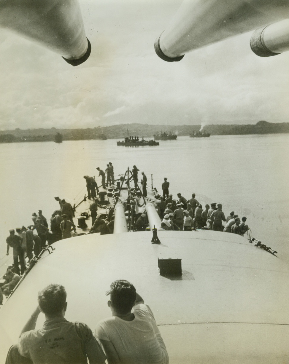 Convoy Supplies a Pacific Outpost, 8/13/1942. Under the protective eyes of a cruiser (foreground), and a destroyer (center), cargo ships of a United States convoy ease into an undisclosed harbor in the Southwest Pacific.  Once safely in, they’ll drop anchor, and unload supplies for an American base. Credit line (ACME);