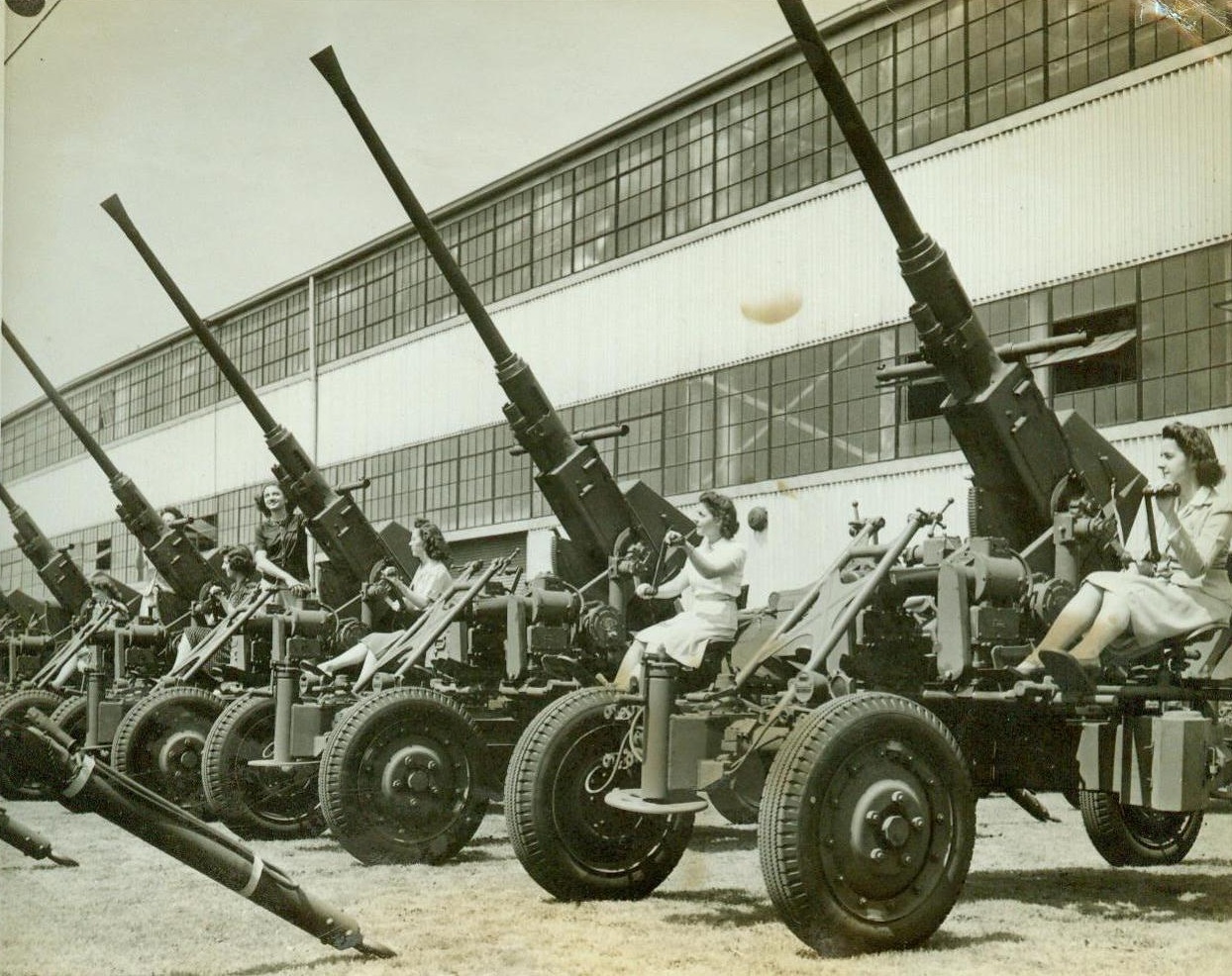 Big Aircraft Guns Easily Maneuvered, 8/28/1943. Akron, Ohio- These Big Bofors Anti-Aircraft guns produced by Firestone Tire and Rubber Co., here are easily maneuvered, as demonstrated by the girls manning the guns in the above photo. Guns are being produes in quantities on production lines here;