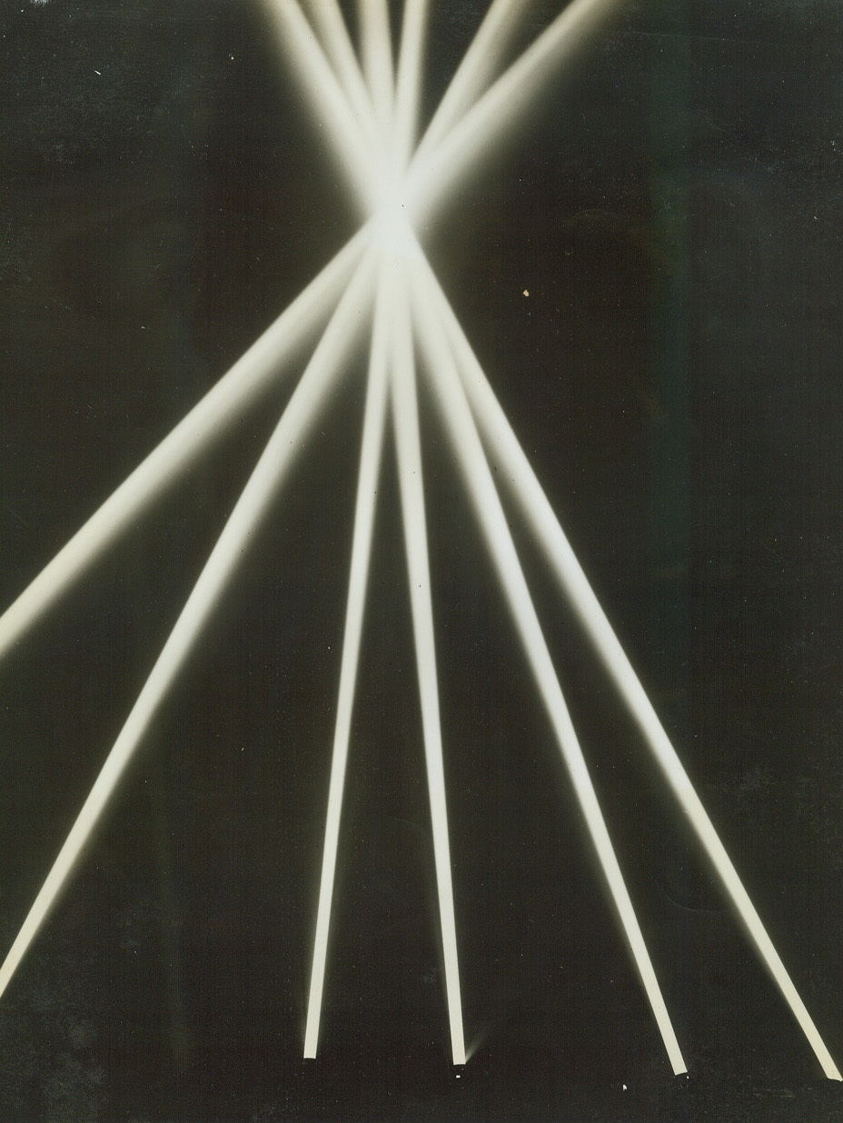 Defense Pattern, 9/29/1942. California—A half-dozen big searchlights of anti-aircraft coast artillery unit holding a practice demonstration in the California desert are converged on a point to show how a number of beams can spot a plan and follow it in flight after it has been located by the unit’s sound detectors.Passed by Army censor.Credit: ACME.;