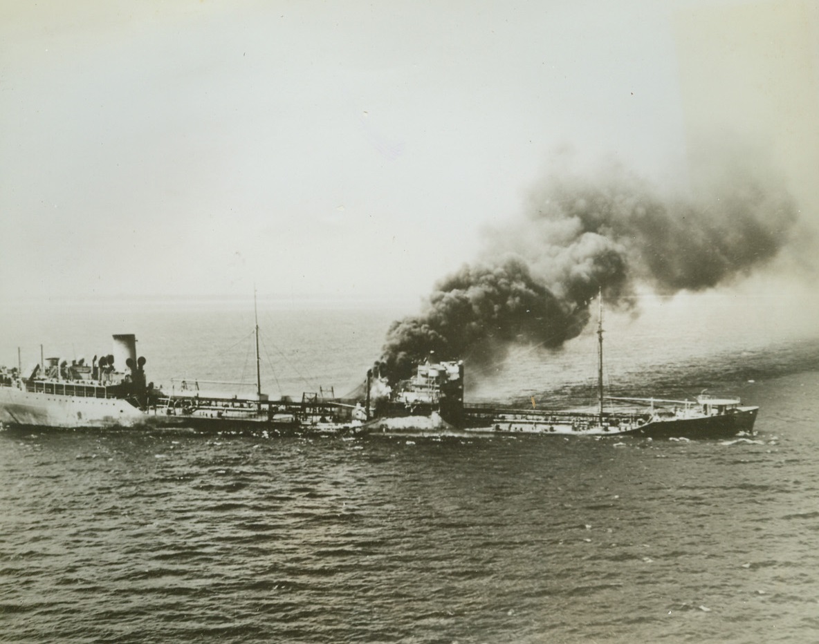 Torpedoed In Battle of Atlantic,  9/29/1942. Billowing black smoke issuing from the amidships on the port side of a Tanker show where an Axis torpedo stuck the vessel in the still-continuing Battle of the Atlantic. Despite the blow the tanker was salvaged. Photo was just released by the U.S. Navy Credit: Official U.S. Navy photo from ACME;