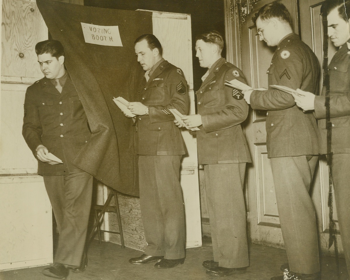 Yanks in Britain Cast Ballots, 11/2/1944. England—American soldiers line up to cast their ballots in voting booth at a polling station for GI’s in Britain. Yanks are recording their votes for the forthcoming Presidential election. Credit: ACME.;