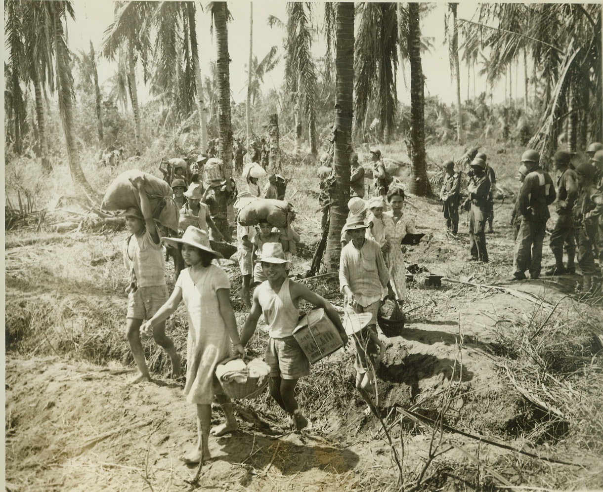 Natives Seek Safety, 11/1/1944. Leyte, Philippines—Each one carrying a few salvaged possessions, Filipinos stream through American lines on Leyte, headed for the comparative safety of the invasion beaches. Photo by ACME photographer Stanley Troutman, for the war picture pool. Credit: ACME.;