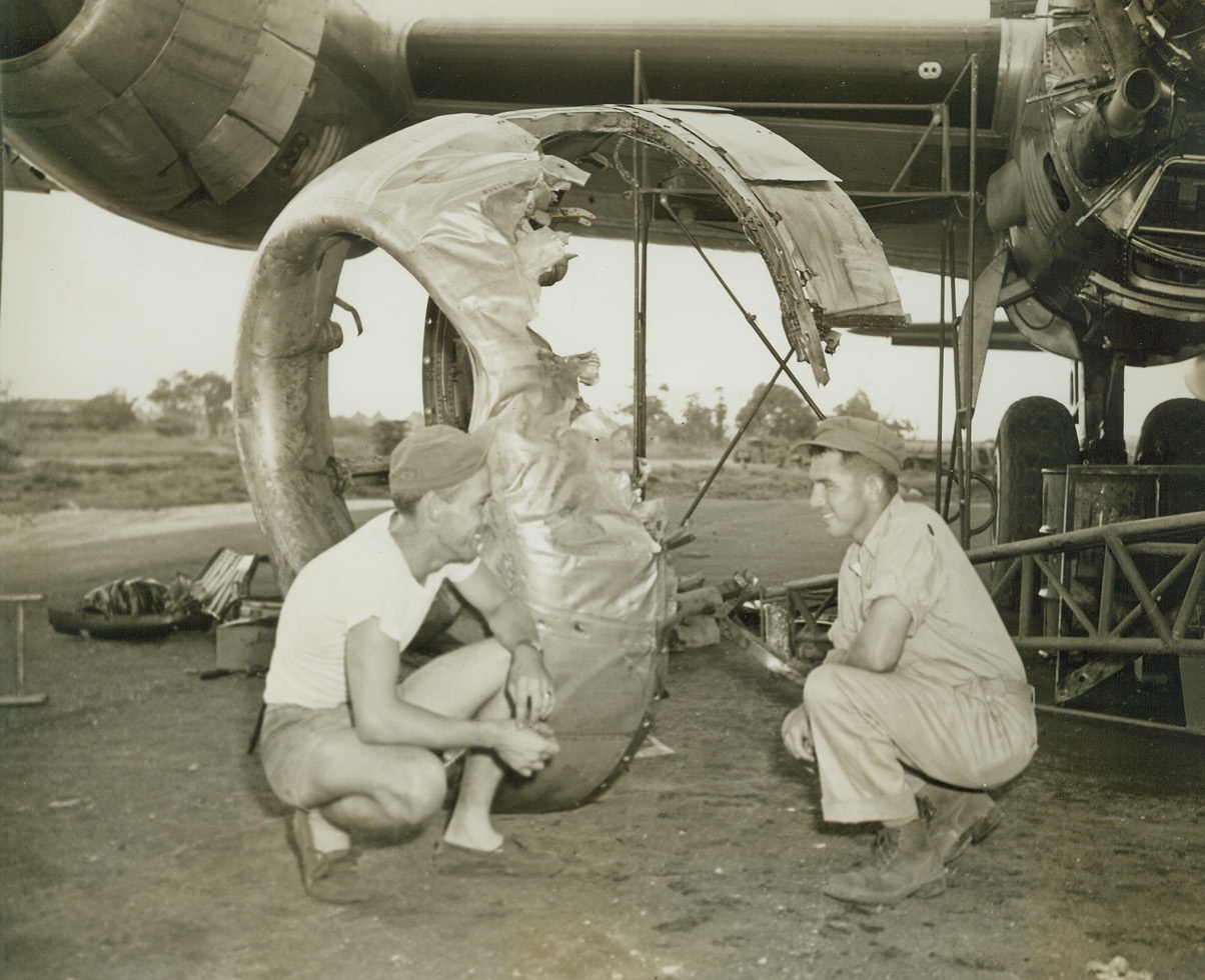 After Jap Plane Rammed Superfort, 12/14/1944. Saipan – Lt. Donald J. Dufford (right), of Grand Junction, Colo., Plane Commander; and Tail Gunner Sgt. R.V. Rainer, Grossbeck, Texas, examine a damaged engine cowling of their B-29 Superfortress, after a Jap Tony Fighter Plane had crashed head-on into the engine on a mission over Japan, Dec. 3. The Nip’s wing was sheared off, it smashed into another Jap and both went down in flames. The Superfort returned to its Saipan base on three engines. Photo by Stanley Troutman, ACME War Pool Photographer. Credit: ACME;