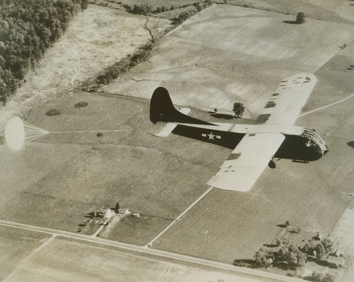 Air Brake, 10/18/1944. Wilmington, Ohio – A CG-4A Glider comes in for a test landing at Army Air Base, Wilmington, Ohio, with a giant nylon parachute serving as an air brake. New development enables gliders to land in smaller areas and reduces accidents. It is contained in a special pack attached to the glider’s tail cone and is opened by a ripcord attachment in the cockpit. Credit: USAAF photo from ACME;