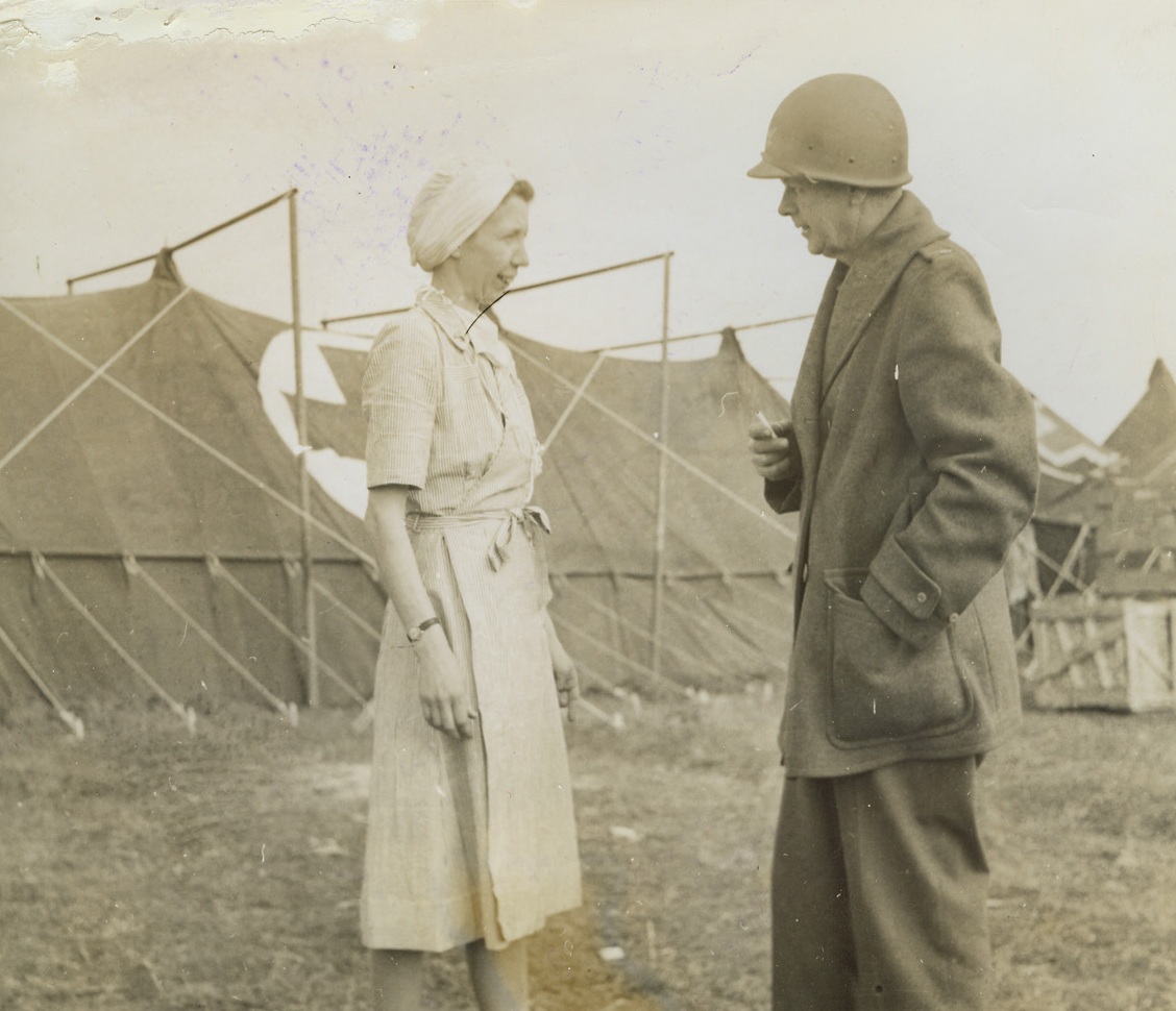 Two Fighters Take a Rest, 2/17/1944. ITALY -- Lt. Mary L. Roberts, of Dallas, Texas, chief nurse in the operating room of an American field hospital in the Nettuno-Anzio beachhead area chats with Col. Henry S. Blisse, of Chicago, Ill. They stand in front of the operation tent where suspension makes inside poles unnecessary. Credit Line (ACME);