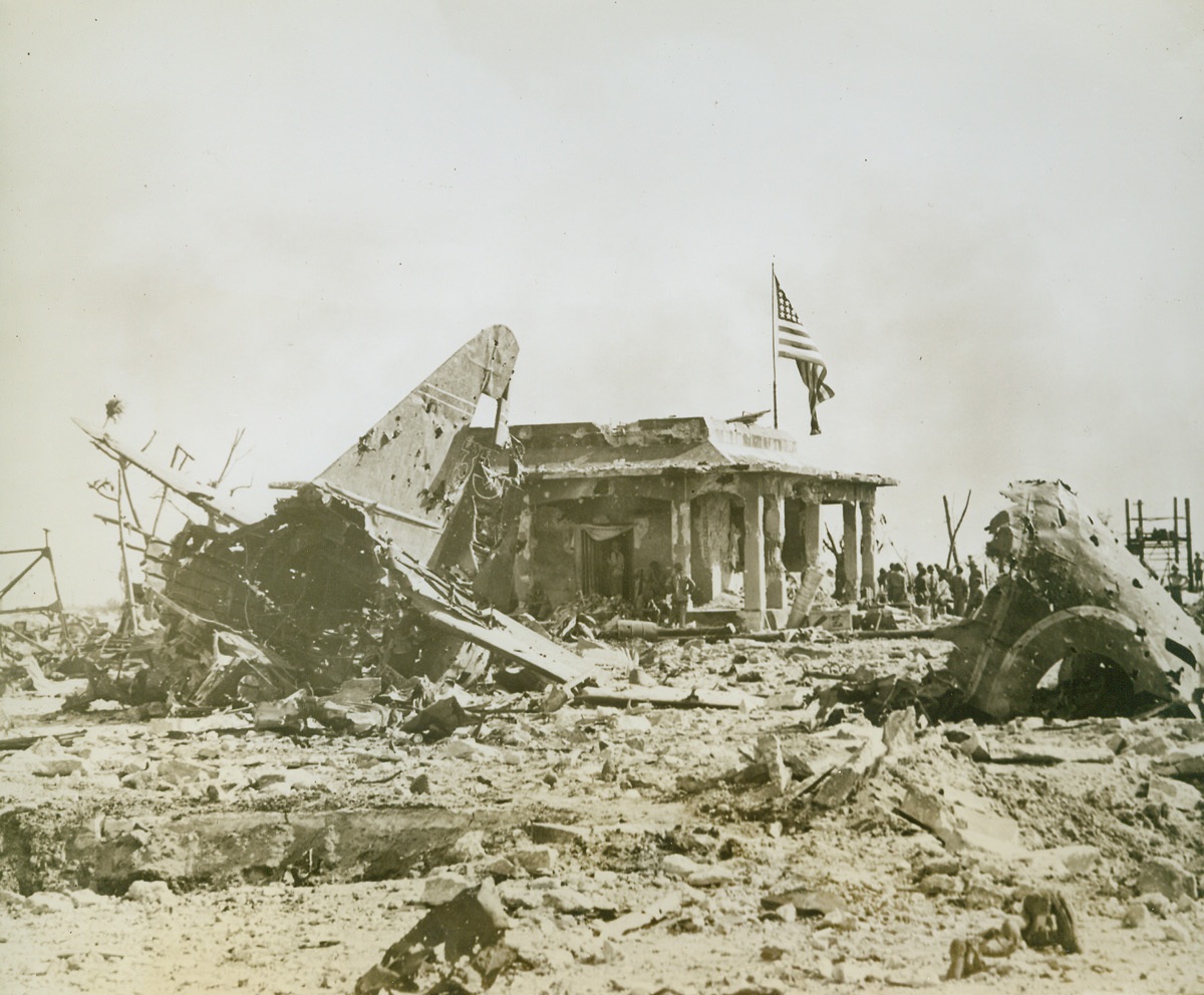 Where Stars Outshone the Rising Sun, 2/19/1944. Namur Island - - The stars and stripes over the battered, former Jap headquarters proclaim complete U.S. victory over Namur island.  What is left of a Japanese bomber (foreground) rests amidst rubble and bits of blased concrete.Credit (U.S. Navy photo from ACME);