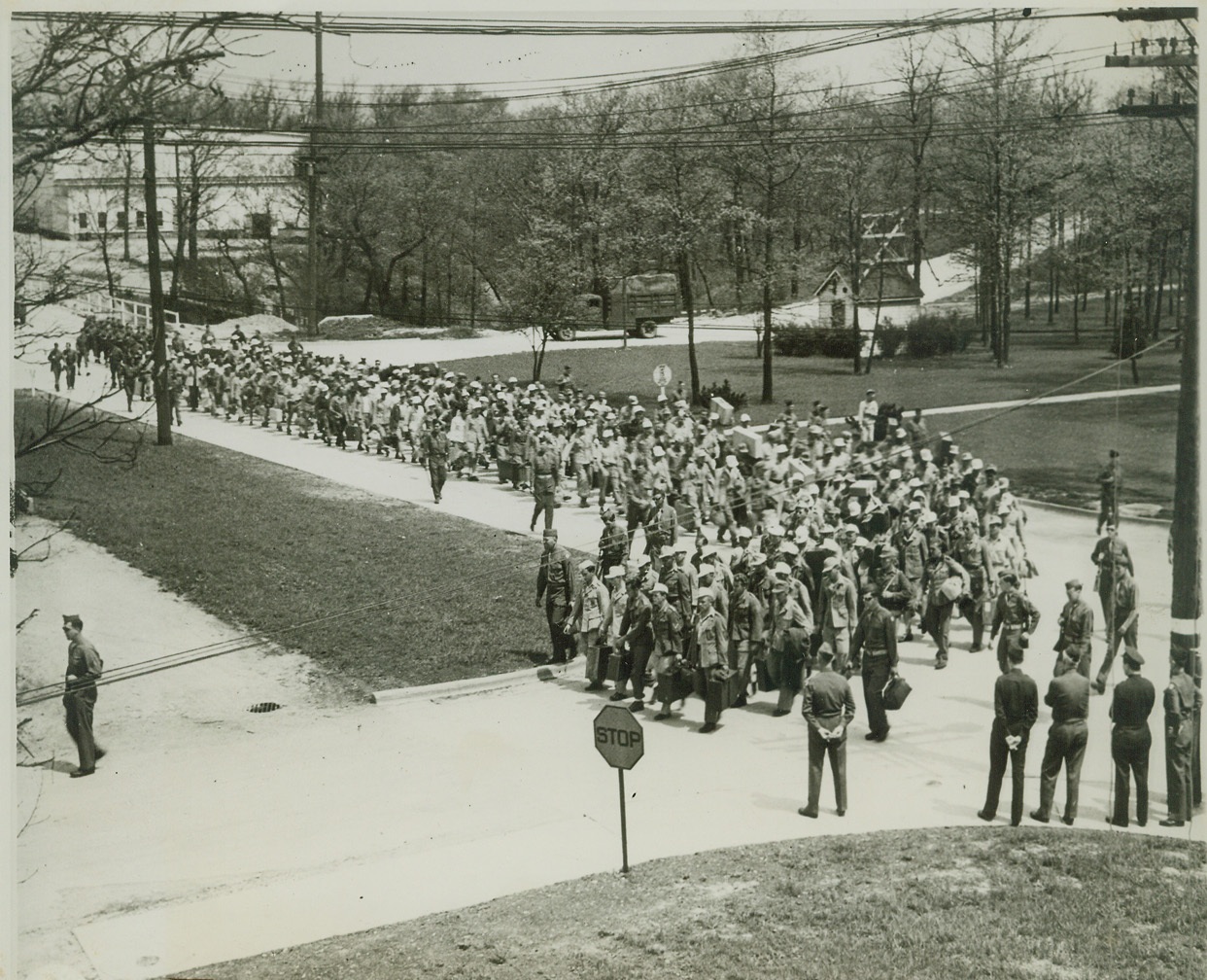 FORT SEES FIRST PRISONERS SINCE INDIANS, 5/20/1944. FORT SHERIDAN, ILL. – A new chapter in the history of Fort Sheridan, Ill., was written when German prisoners, many of them wearing uniforms in which they were captured, marched down the street on their way to the stockade where they will be confined. The Nazi ex-soldiers transferred from Camp Leonard Wood, Mo., are the first prisoners of war to arrive at Fort Sheridan since the internment of the last of the warring Indians. Credit: OWI Radiophoto from ACME;
