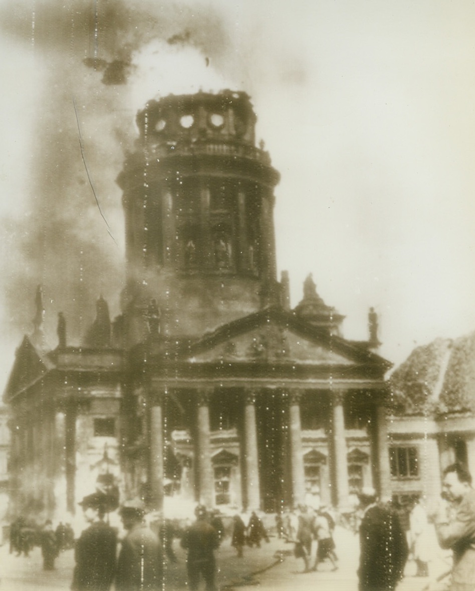 American Raid Hits French Cathedral, 5/30/1944. Berlin – According to the German caption on this photo radioed today from Stockholm, this is the Franzoesischer Dom (French Cathedral) on the Gendarmenmarkt, in Central Berlin, damaged and blazing after the American daylight raid on the German capitol on May 24th.  Credit: (ACME Radiophoto);