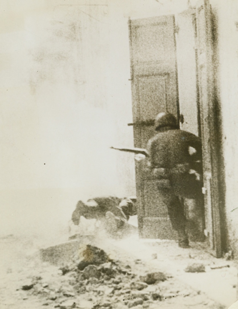 AND ONE WAS HIT (#3), 5/7/1944. ITALY—This is the last photo in a dramatic sequence made in an unnamed Italian village as three U.S. scouts fought a building-to-building scrap against entrenched Nazis. Here one of them is hit by a Nazi bullet and falls as his two comrades quickly dart into an open door for momentary shelter. White could is probably caused by exploding grenade.Credit: Signal Corps newsreel photo from Acme;