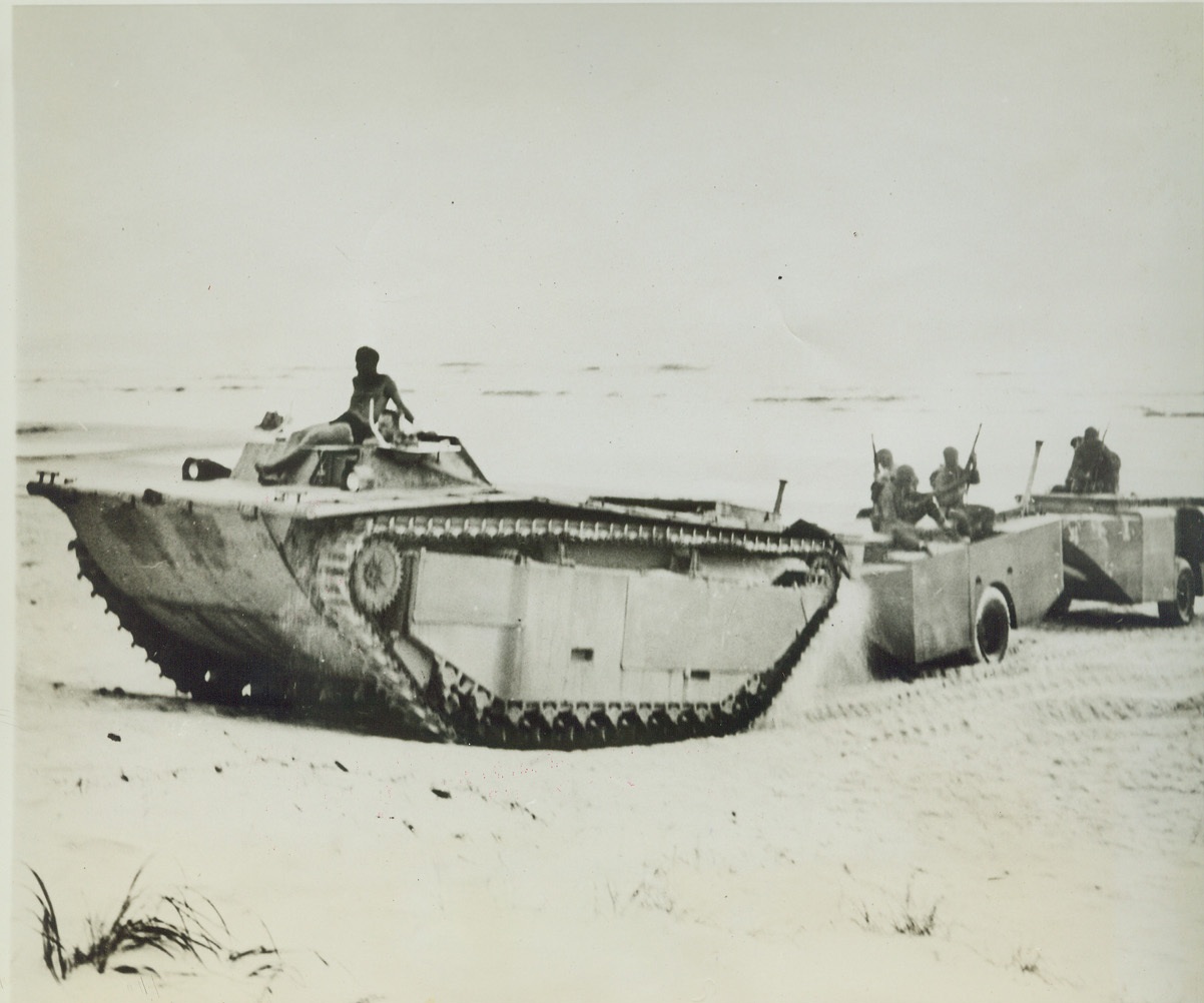 AMPHIBIOUS SUPPLY TRAILERS, 8/13/1944. CAMP LEJEUNE, N.C. – An amphibious tractor hauls ashore a new amphibious cargo trailer during a series of test by US Marines. The water-tight trailers have a capacity of 220 cubic feet. When used in combat, they will insure the delivery of supplies in a more usable condition. Credit: U.S. Marine Corps photo via OWI Radiophoto from ACME;