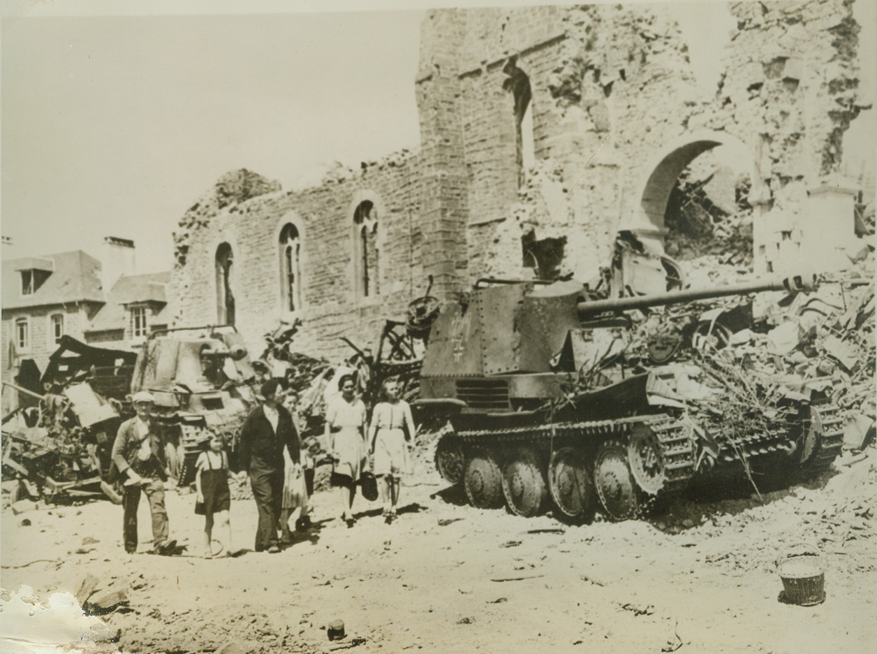 UNWELCOME GUEST IN RONCEY, 8/11/1944. RONCEY, FRANCE – These citizens of Roncey, returning to their home town after the wave of battle had swept past it, are greeted by wreckage and debris-strewn streets. German tanks and other pieces of wrecked or abandoned enemy equipment litter the roads. Credit: ACME;
