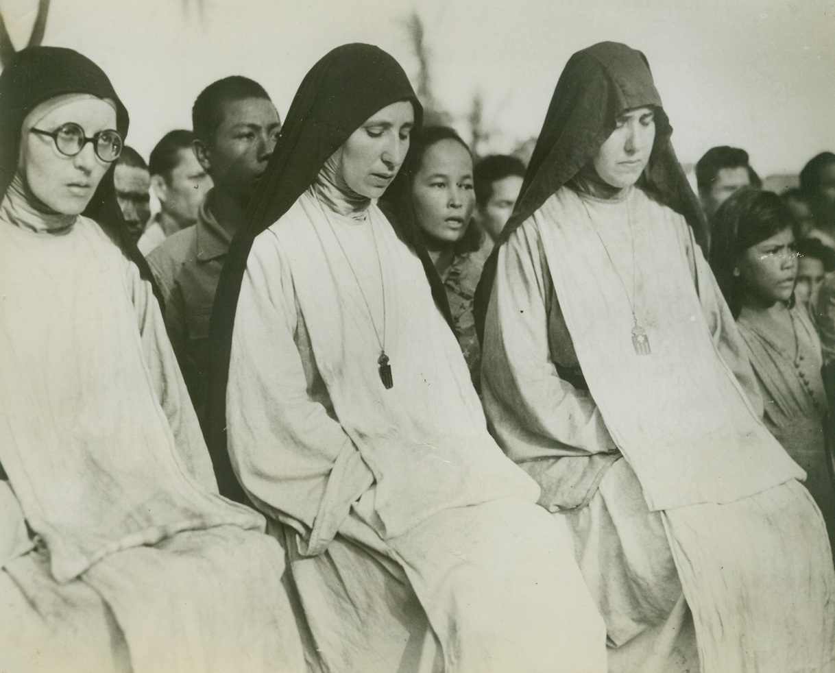 NUNS ATTEND FIRST MASS ON LIBERATED SAIPAN, 8/1/1944. SAIPAN ISLAND—Catholic nuns attend the first Mass held on Saipan since 1940, when the Japanese abolished Christian rites. Attending Mass with them are other civilians freed from the Japs by the capture of Saipan by the U.S. “triphibian” (air-land-sea) forces.Credit: Official U.S. Navy photo from Acme;