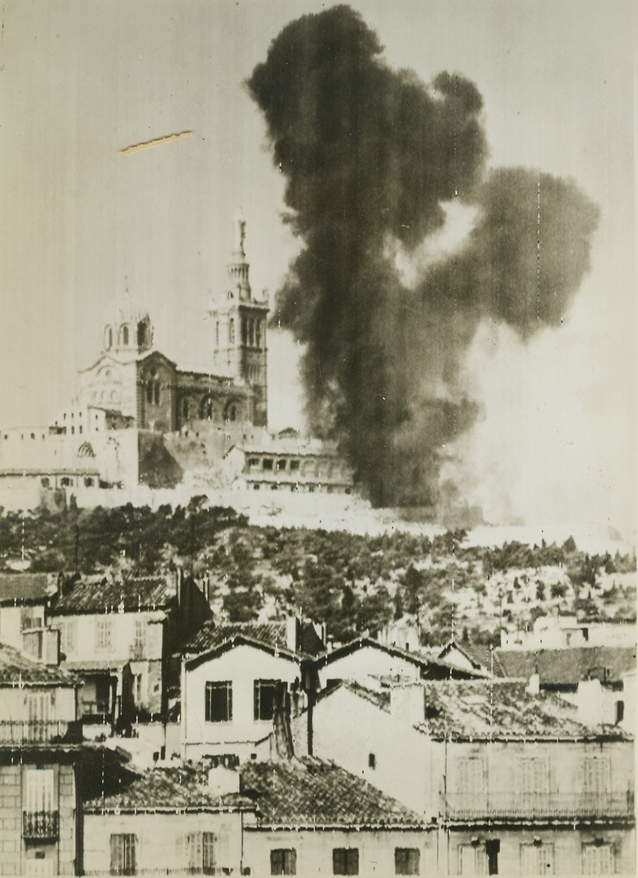 Cathedral An Enemy Target, 8/31/1944. FRANCE -- Smoke rises from a hit near the famous Cathedral of Notre Dame De La Garde situated on a hill in Marseille and the target for German fire after the city was captured by French forces. Credit (Army Radiotelephoto From ACME);