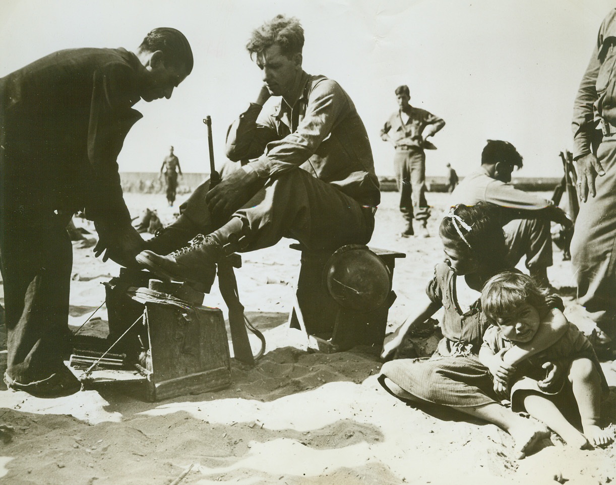 Polishing Up for Invasion of “Fashion Center”, 8/19/1944. ITALY – All set for style-conscious France is Pfc. James P. Royle, Boston, Mass., getting a last minute shoeshine before shoving off from an Italian port for the invasion of Southern France. Credit (Signal Corps Photo from ACME);
