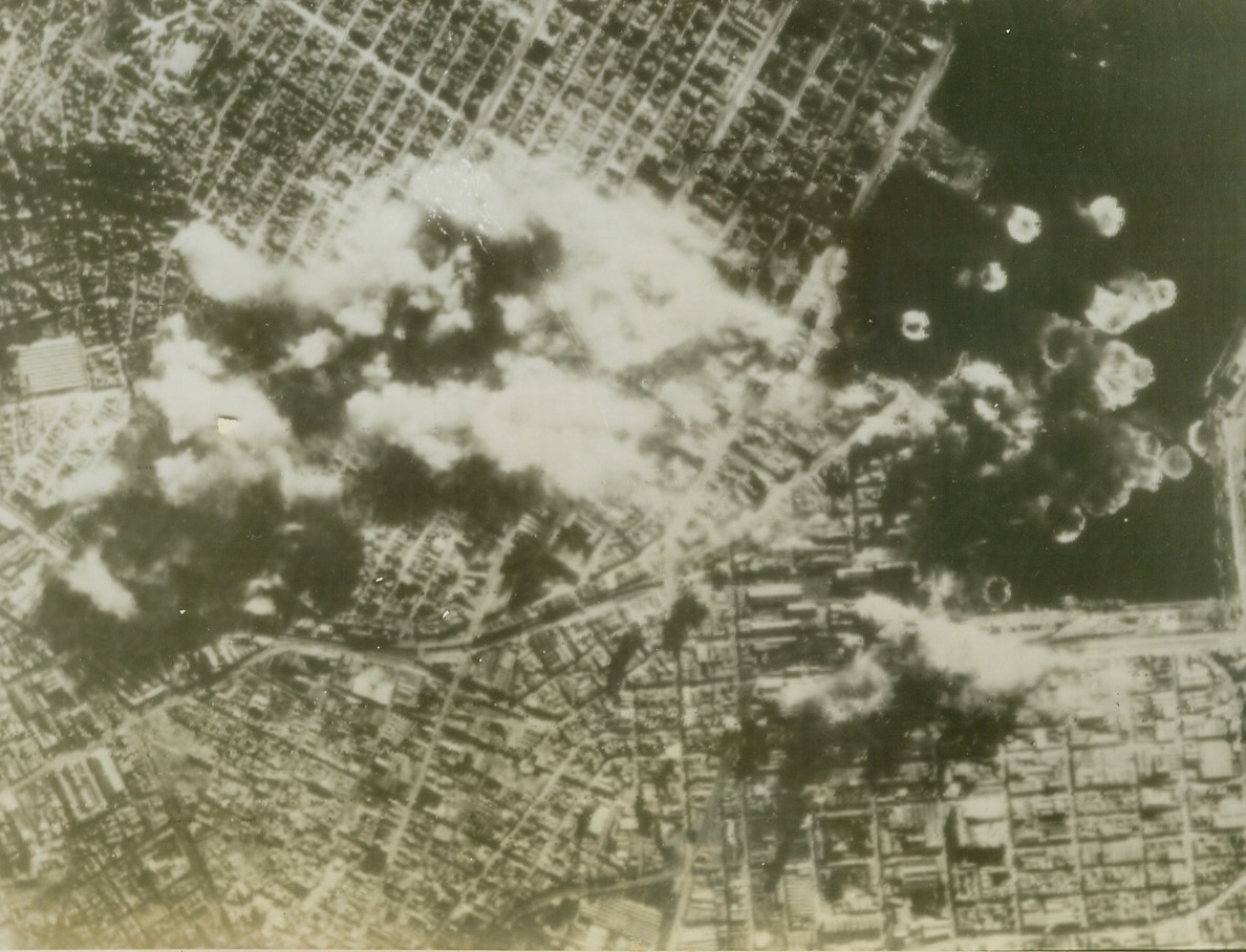 U.S. Bombers Slug Port of Athens, 8/15/1944. ATHENS, GREECE – Smoke shrouds the already battered dock area of Athens as U.S. Flying Fortresses bomb the vital Nazi supply center, on January 11th. Bomb-bursts dot the harbor waters as the B-17’s of the 15th United States Army Air Force wing over their target. Credit (U.S. Army Air Force Photo Via OWI Radiophoto from ACME);