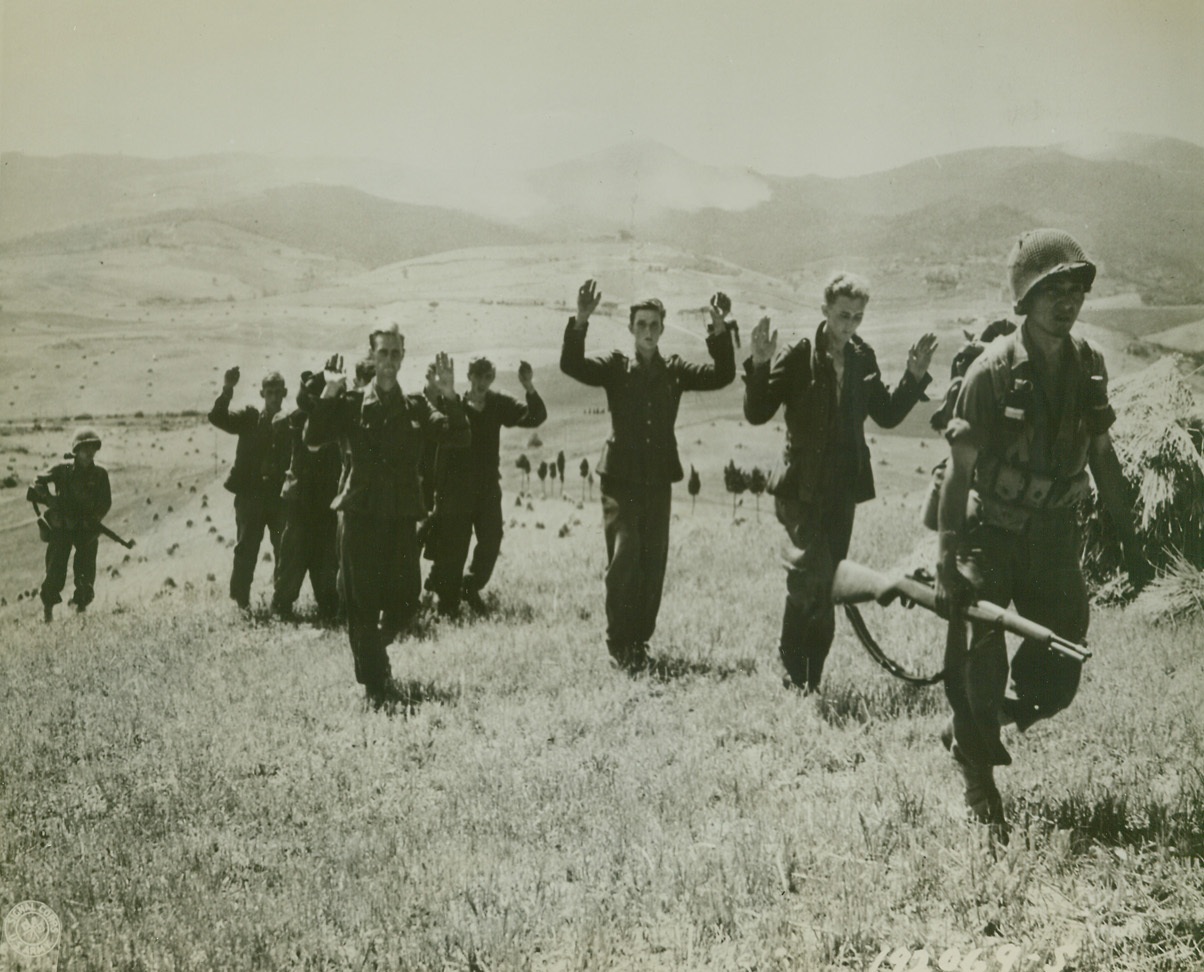 Hands Up – Give Up, 8/7/1944. ORCIANO, ITALY – Holding their hands high, German storm troopers follow their American captors after a short but sharp exchange of fire in the Orciano area. The enemy warriors surrendered to the riflemen of the 100th Infantry Battalion – Americans of Japanese ancestry. Credit Line (Official U.S. Army Photo from Acme);