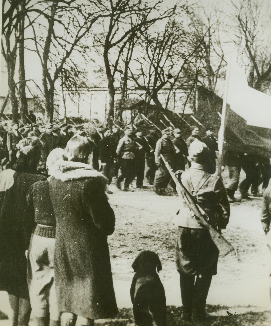 Polish Patriots on Parade, 8/23/1944. POLAND – After church services celebrating Poland’s National Day (May 3rd), Polish guerilla fighters troop past their colors in a town 120 miles southwest of Warsaw. The patriots are members of the Nrubieszow (Podleze) battalion of their country’s home army. Photo obtained through a neutral source.Credit Line (Acme);